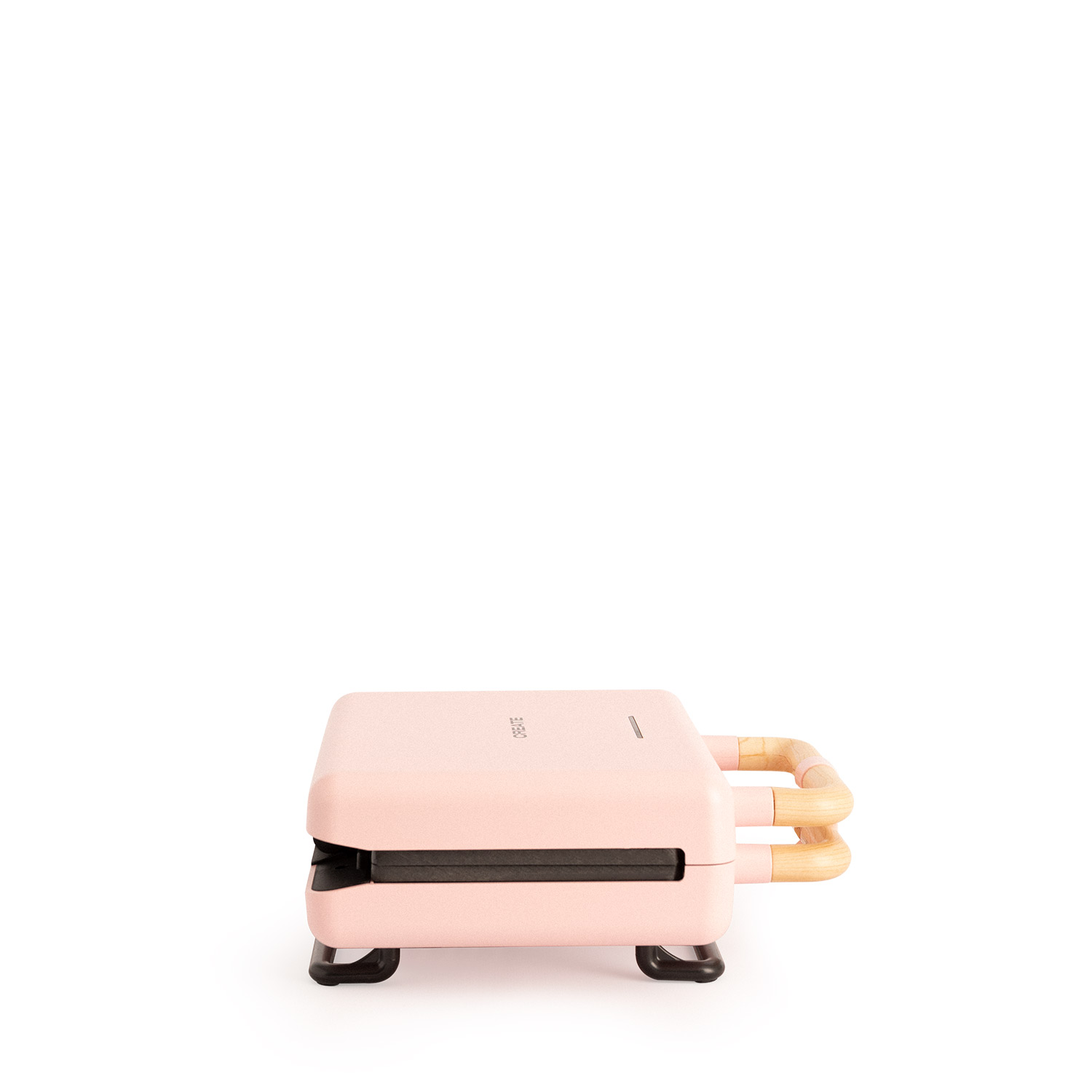 Máquina para hacer gofres rosa con mangos de madera, aislada sobre fondo blanco.