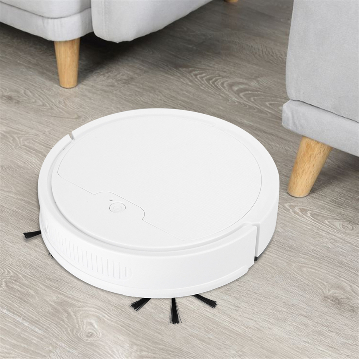 Weißer Roboter-Staubsauger auf Holzboden, in der Nähe von zwei grauen Stühlen.