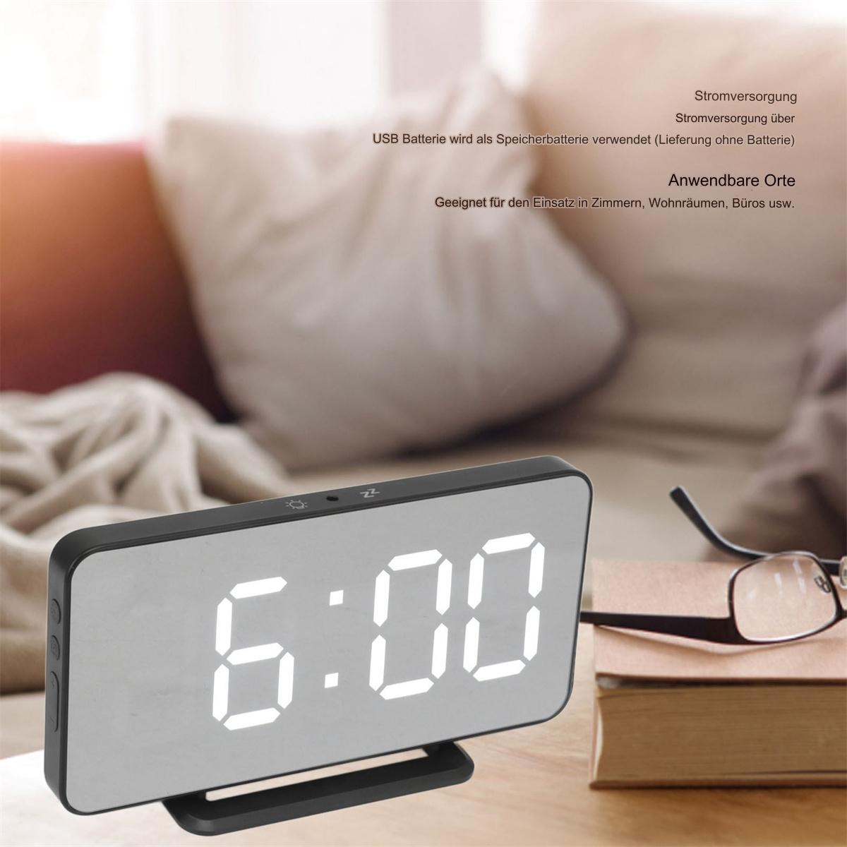 Digitaluhr mit der Anzeige 6:00, auf Holzoberfläche mit Brille.