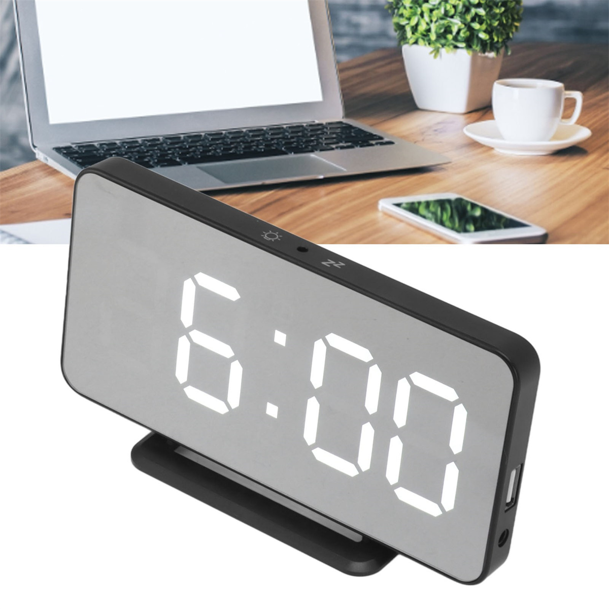 Digitaluhr mit der Anzeige 6:00 Uhr. Auf einem Schreibtisch mit Laptop, Pflanze und Kaffeetasse im Hintergrund.