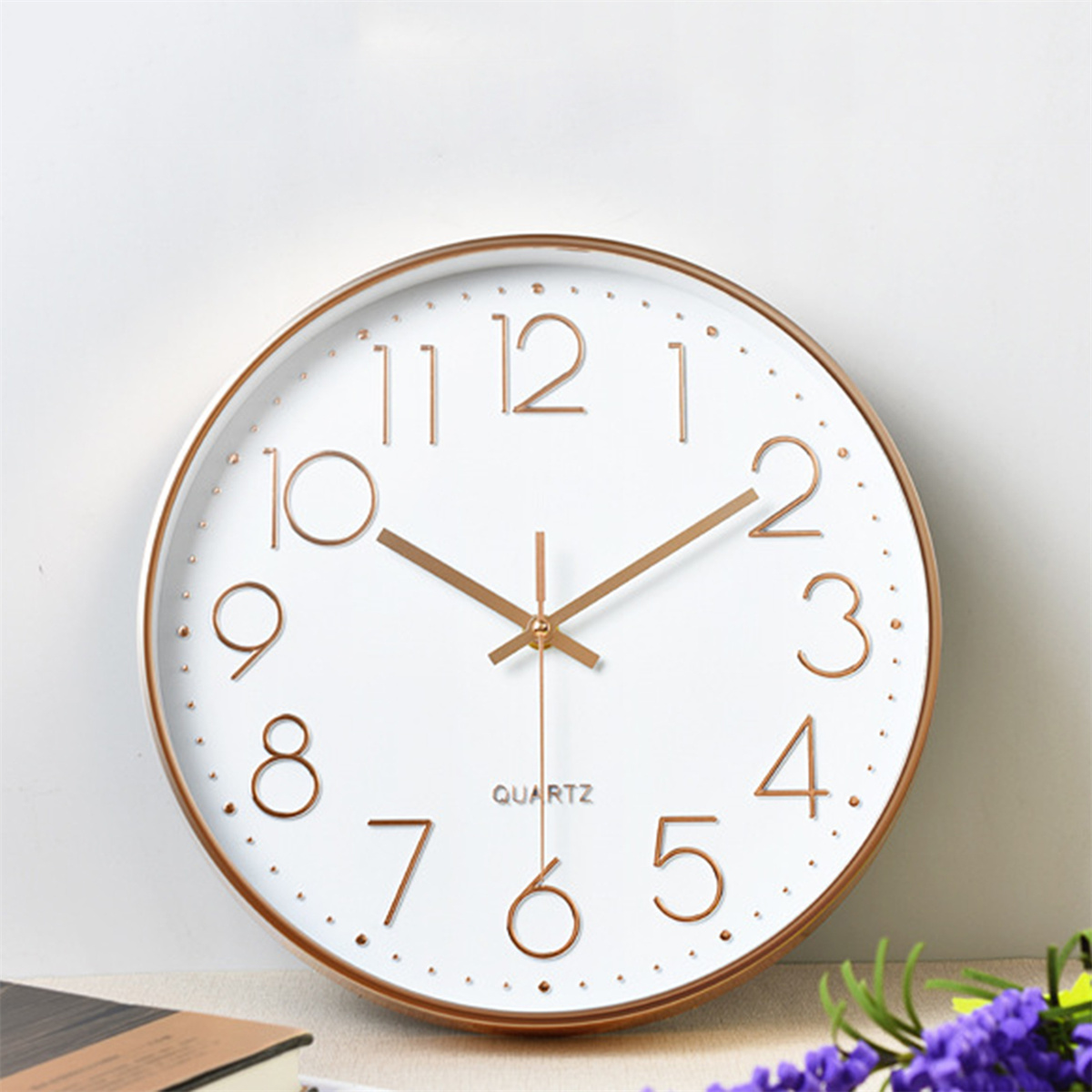 Weiße Wanduhr mit goldfarbenem Rahmen und Ziffern. Quarz ist unter den Zeigern aufgedruckt.