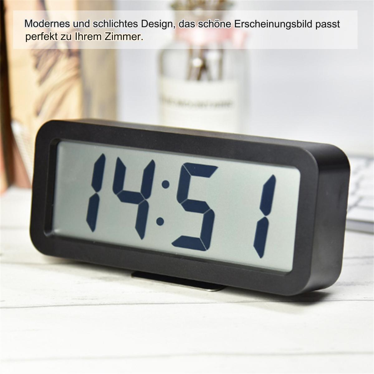 Digitaluhr mit der Anzeige 14:51 auf einem Holztisch mit verschwommenem Hintergrund.