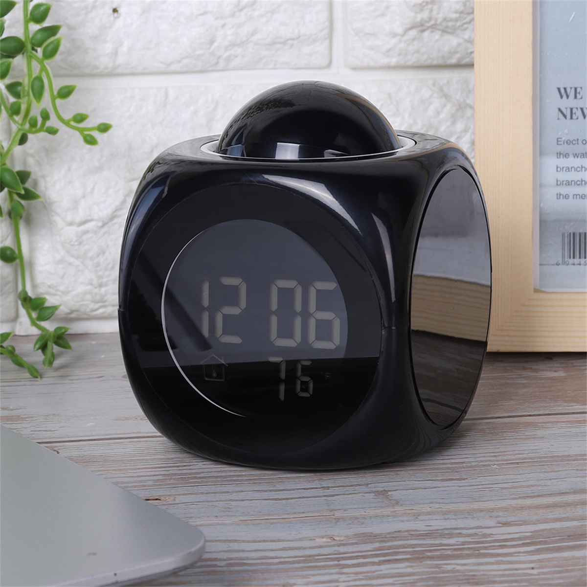 Schwarze Würfeluhr mit Digitalanzeige, zeigt Uhrzeit und Temperatur an.