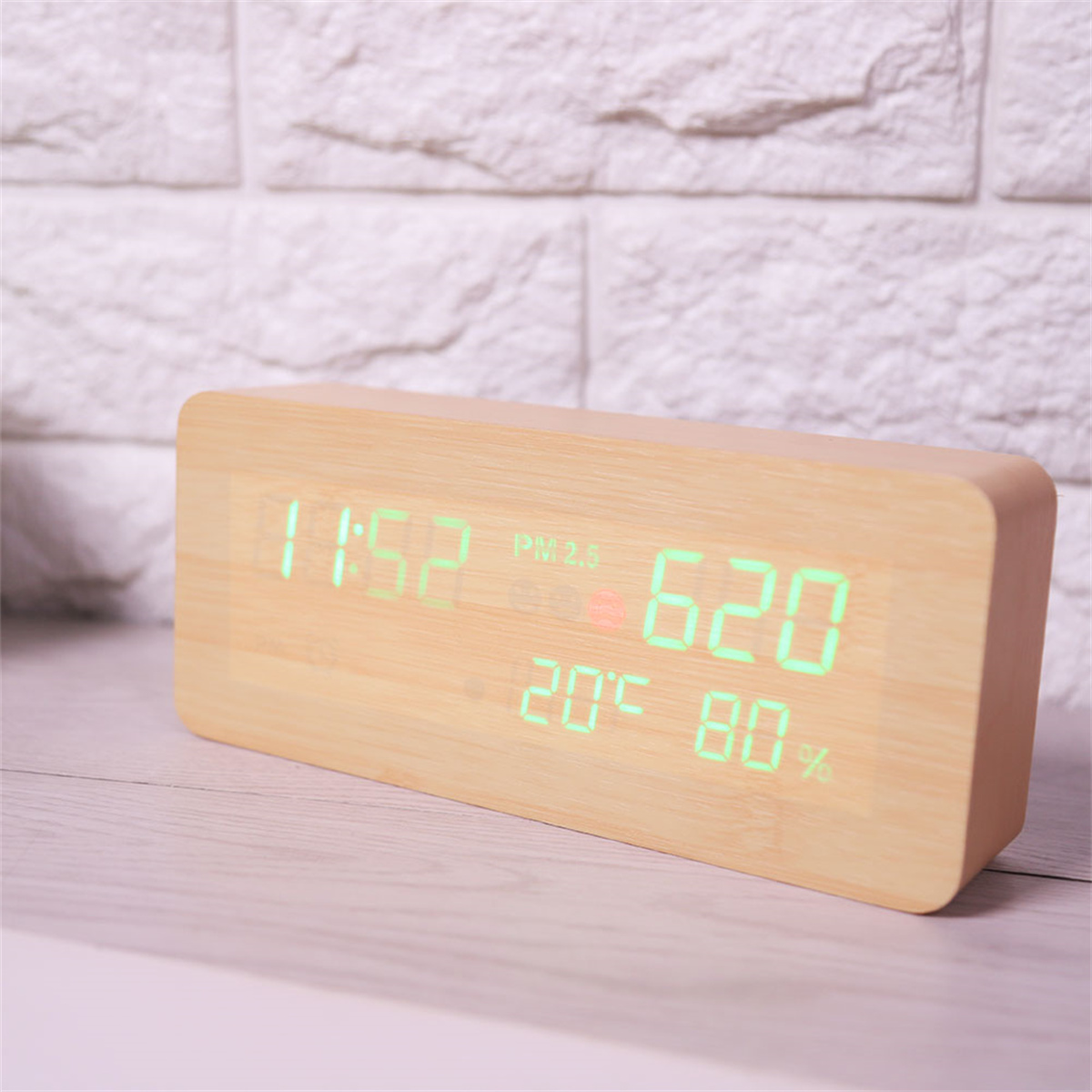 Digitaler Wecker aus Holz mit Anzeige von Zeit, Temperatur und Luftfeuchtigkeit auf weißer Oberfläche.