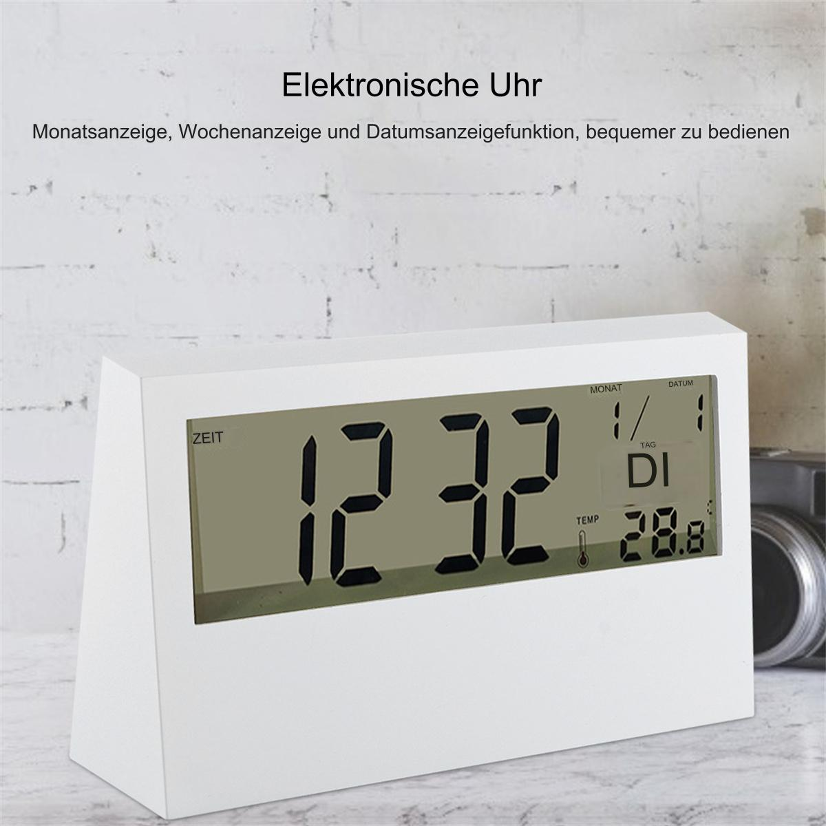Eine weiße Digitaluhr, die Zeit, Datum und Temperatur auf einer Oberfläche anzeigt.