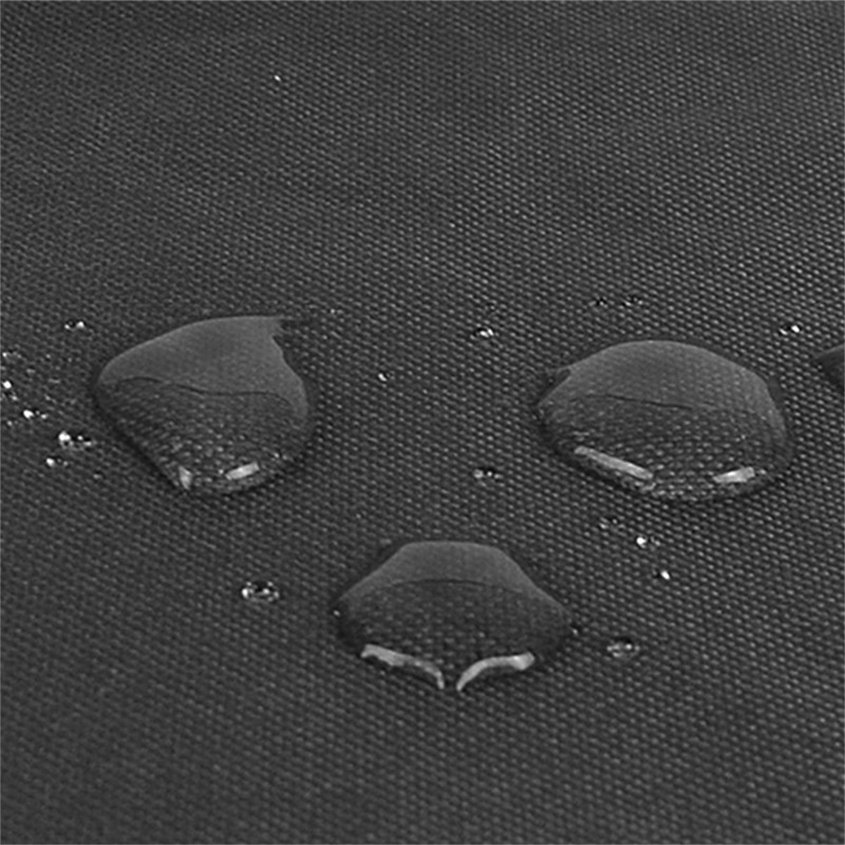 Nahaufnahme von dunklem Stoff mit Wassertropfen auf der Oberfläche, die Licht reflektieren.