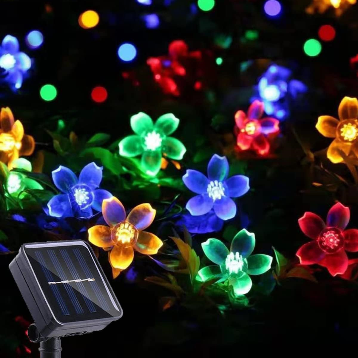 Solarbetriebene Lichterkette mit bunten blütenförmigen Lichtern. Ein Solarpanel befindet sich am Boden.