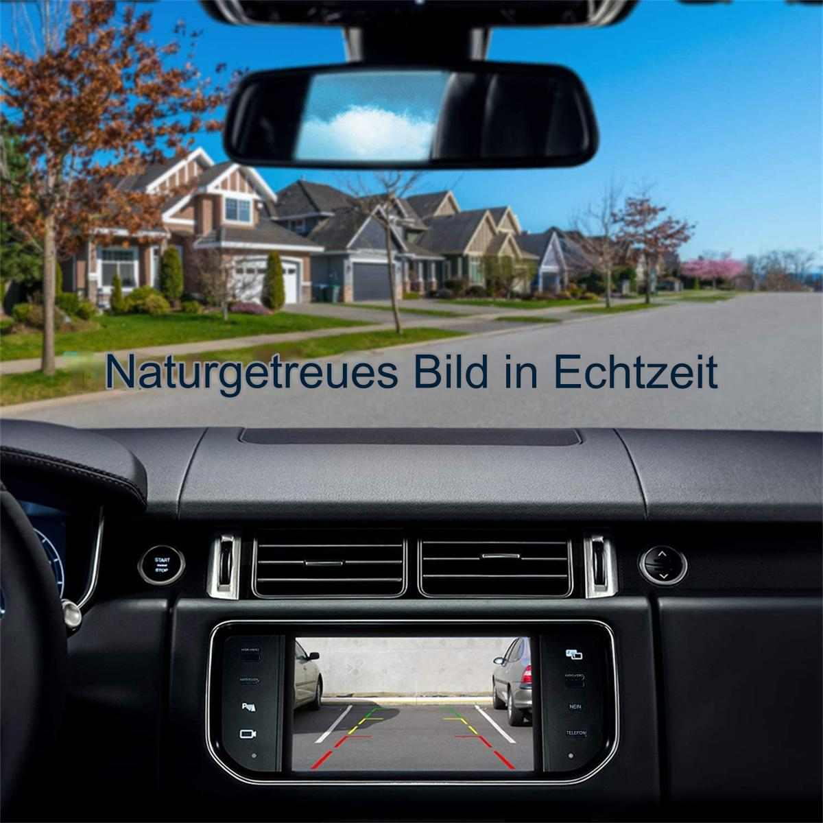 Innenansicht aus einem Auto mit Bildschirm, der eine Straße und ein Haus im Hintergrund zeigt.