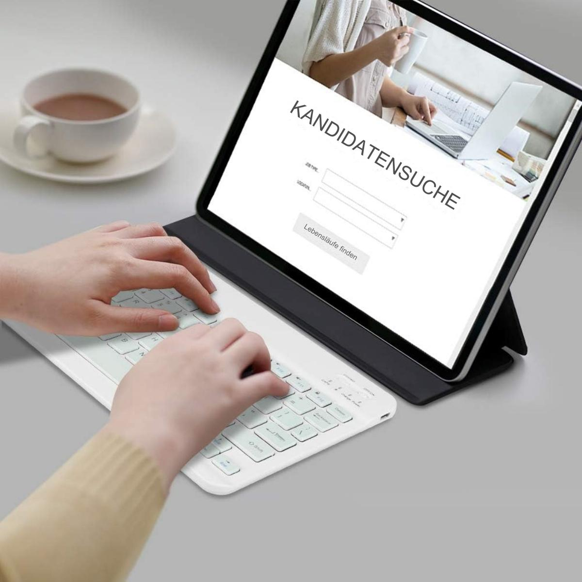 Eine Person, die eine weiße Tastatur verwendet, die mit einem Tablet verbunden ist, das eine Job-Such-Website anzeigt.