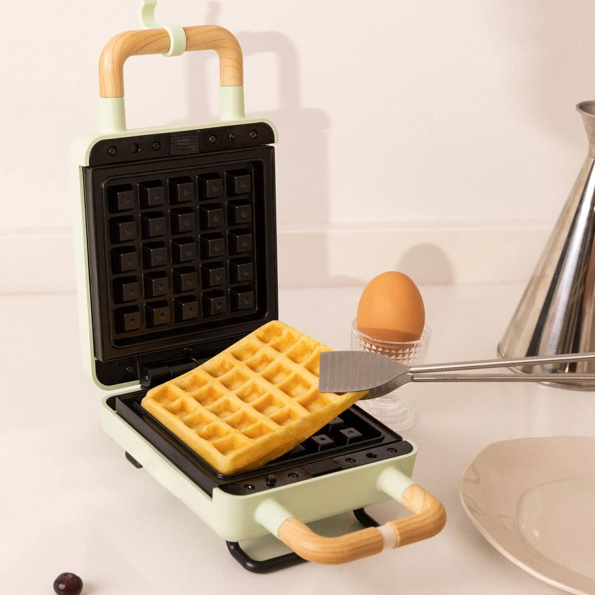 Máquina para hacer gofres con gofre cocido, huevo en soporte de vidrio.