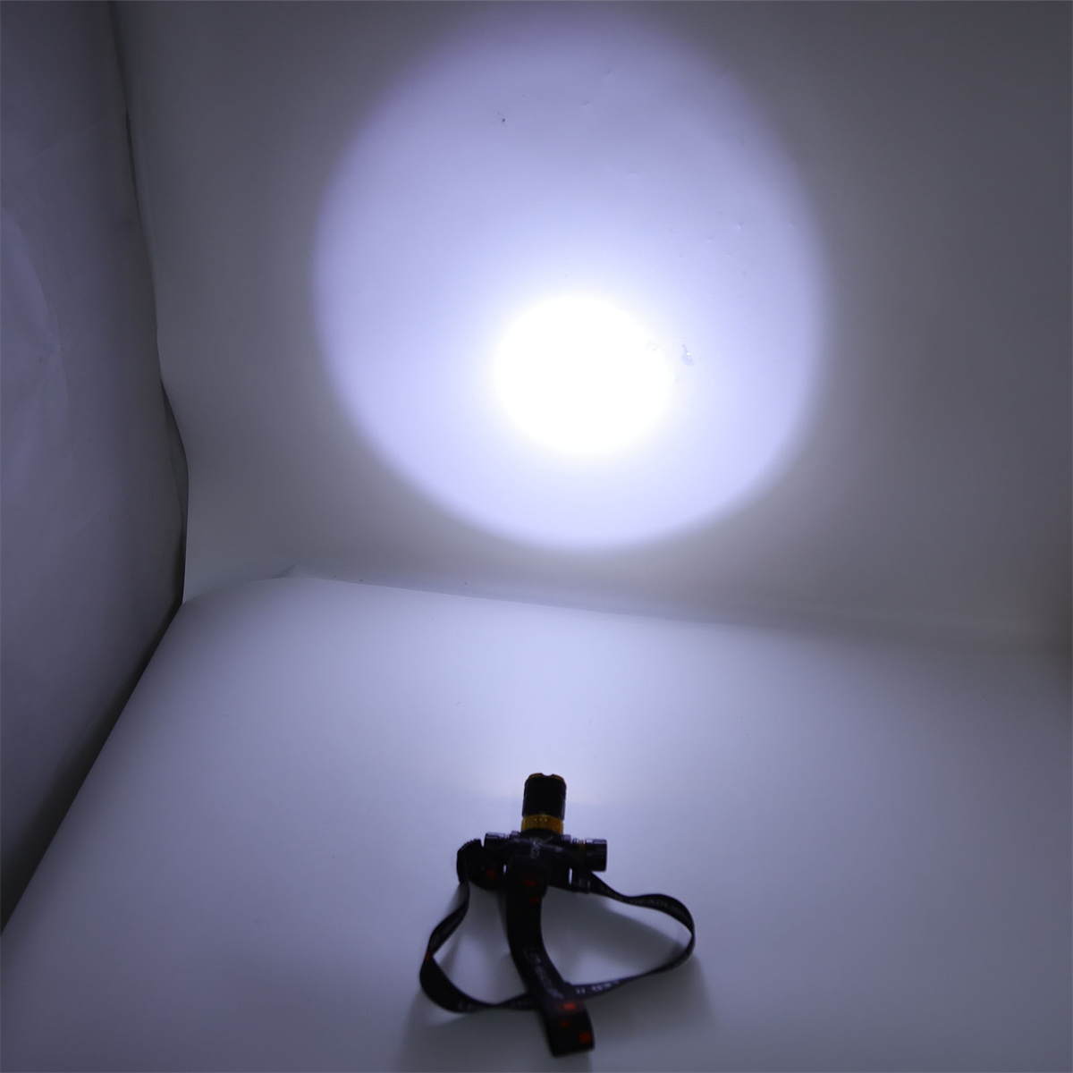 Eine Stirnlampe, die ein helles weißes Licht auf einem weißen Hintergrund ausstrahlt.