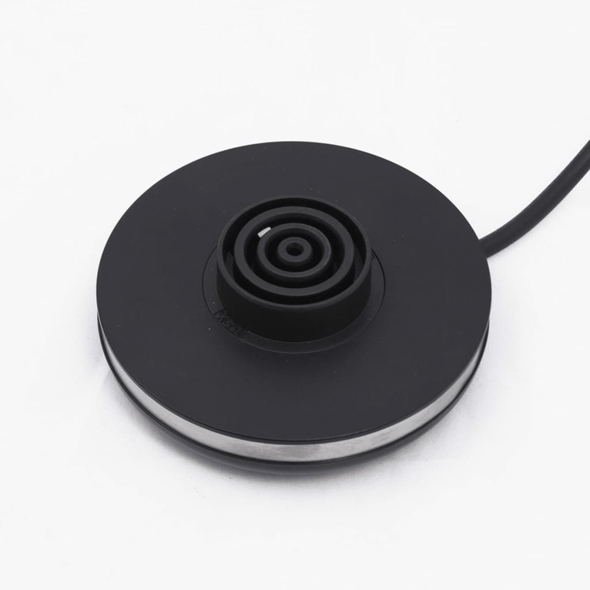 Black base of an electric kettle. A round base with a central connection point.