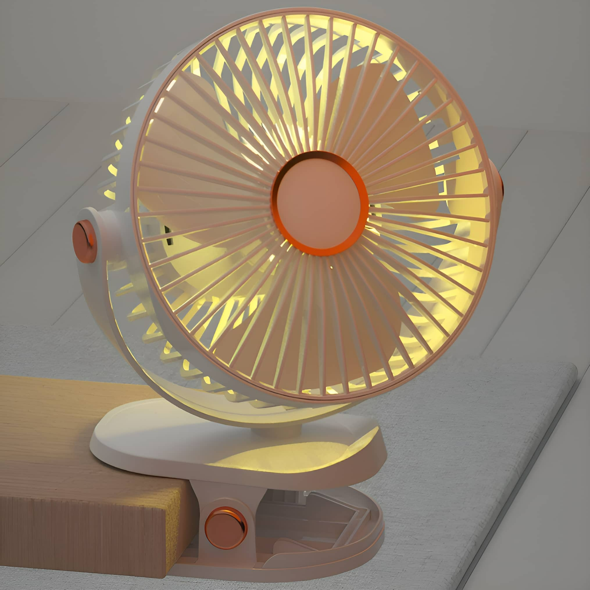 Ein weiß-rosa Ventilator mit Clip steht auf einer Holzoberfläche. Der Ventilator ist beleuchtet.