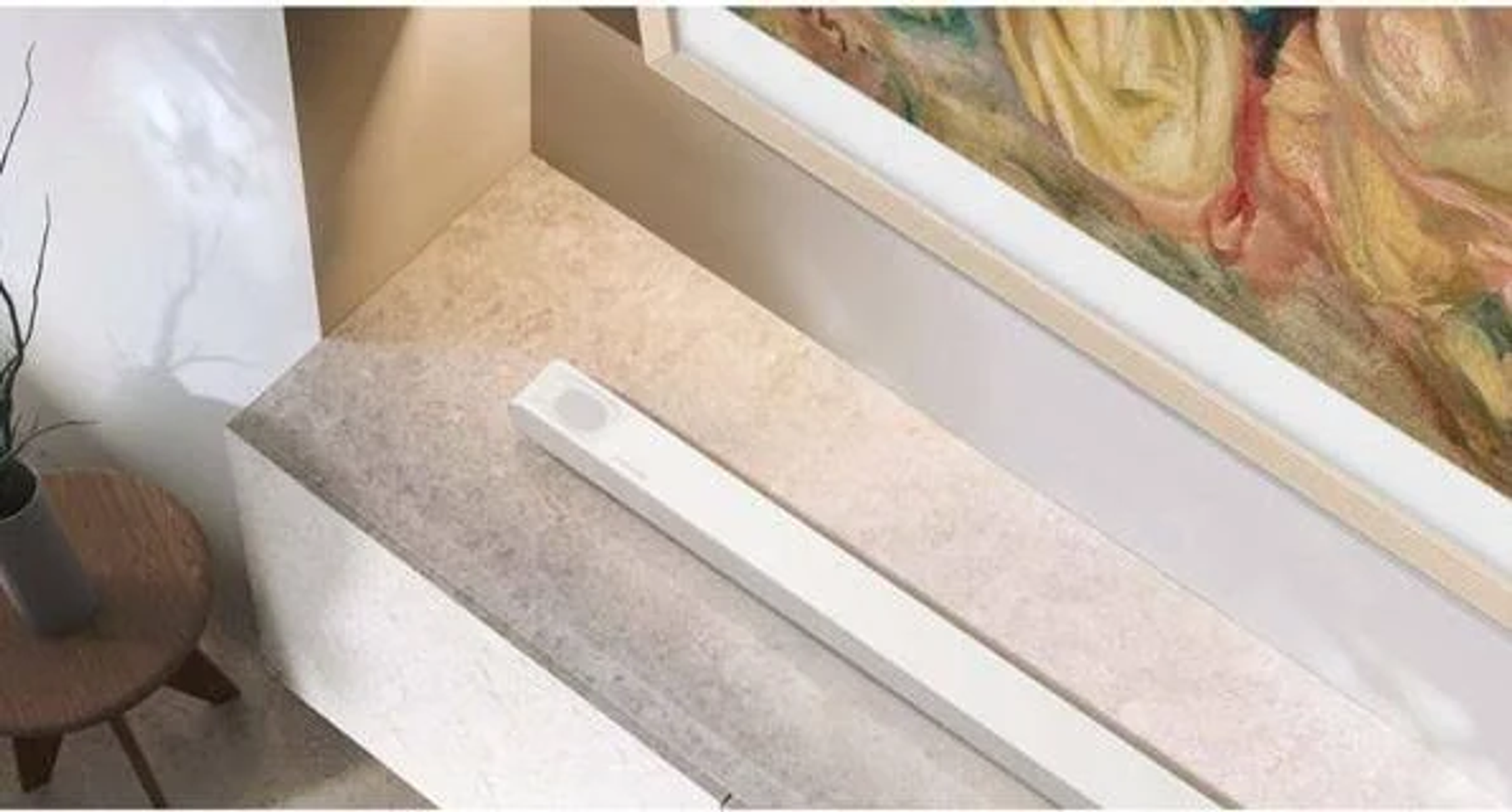 Modernes Interieur mit einer weißen Soundbar auf Marmoroberfläche.