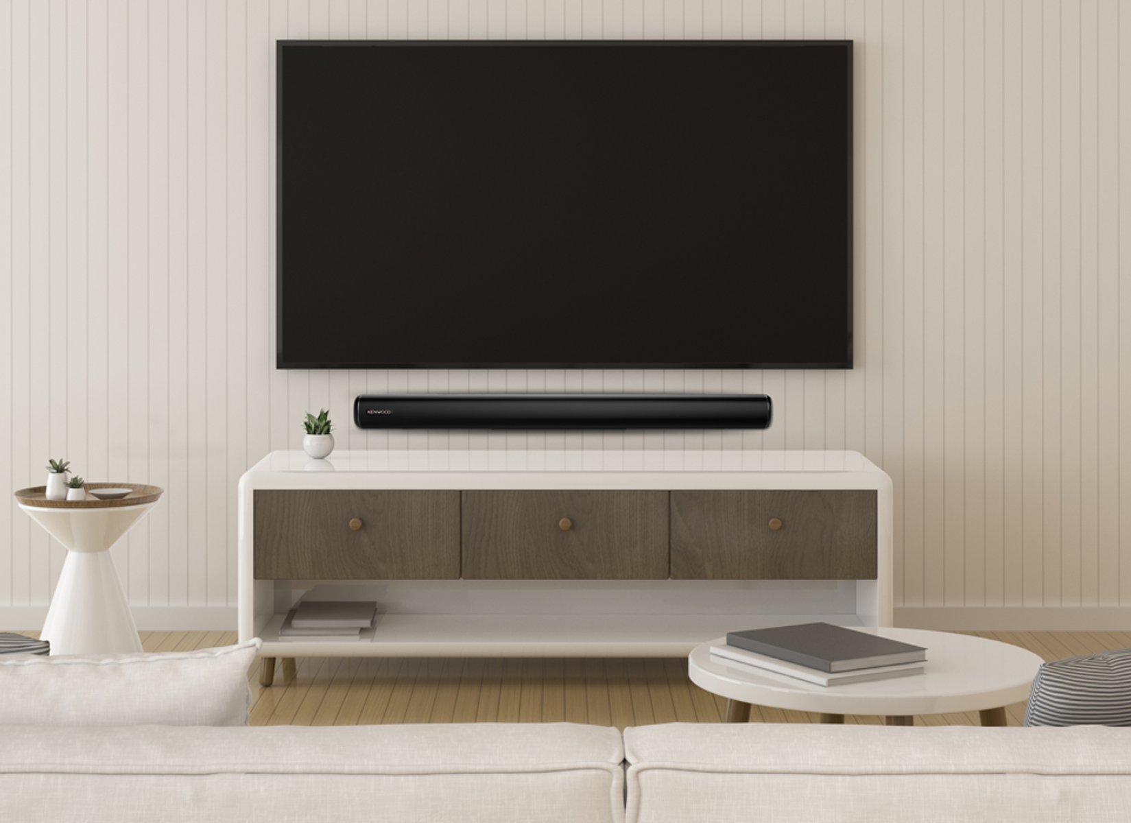 Soggiorno con TV e soundbar su un mobile bianco. Divano e tavolino sulla sinistra.
