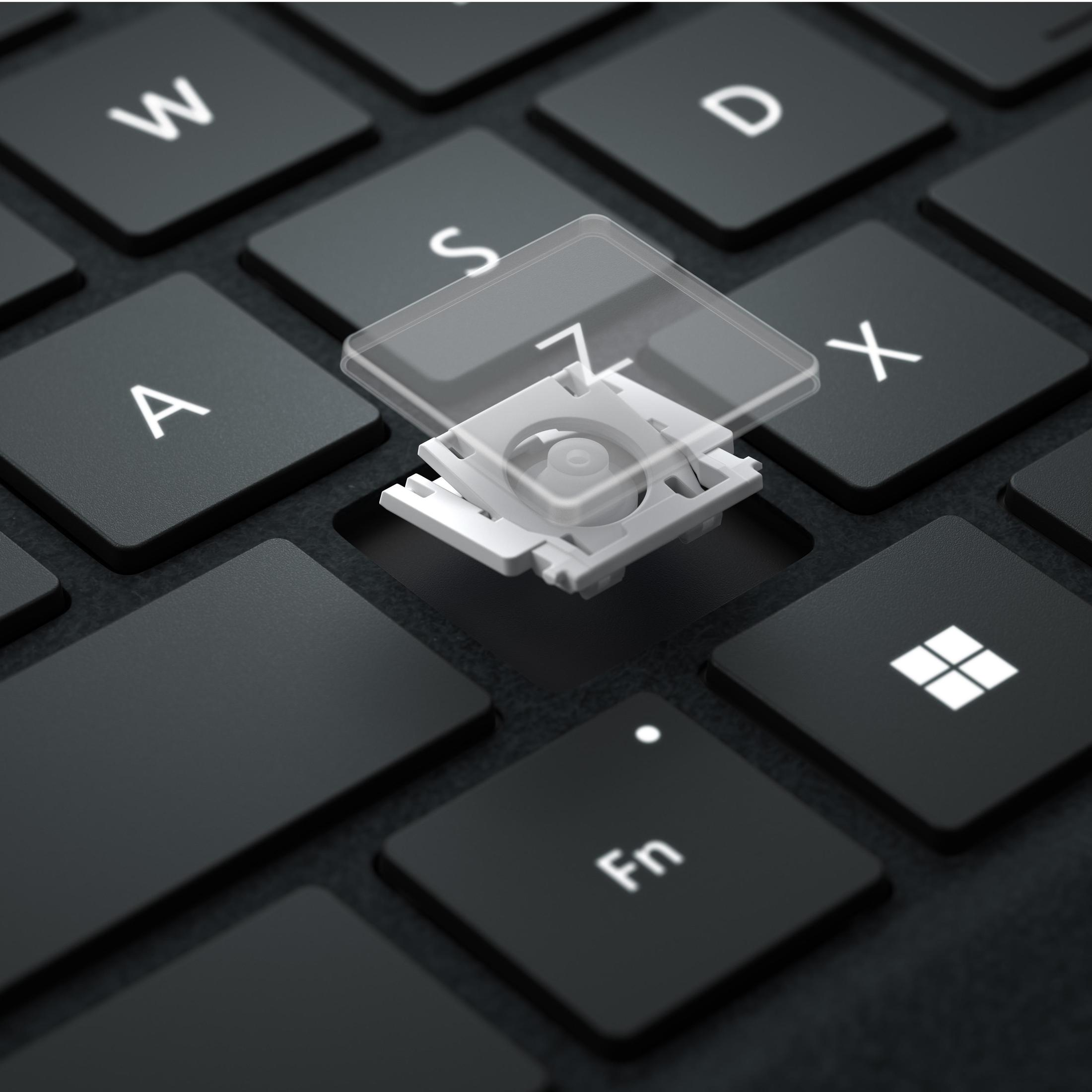 Tastatur mit entfernter Z-Taste, Mechanismus sichtbar. Schwarze Tasten und weiße Elemente.