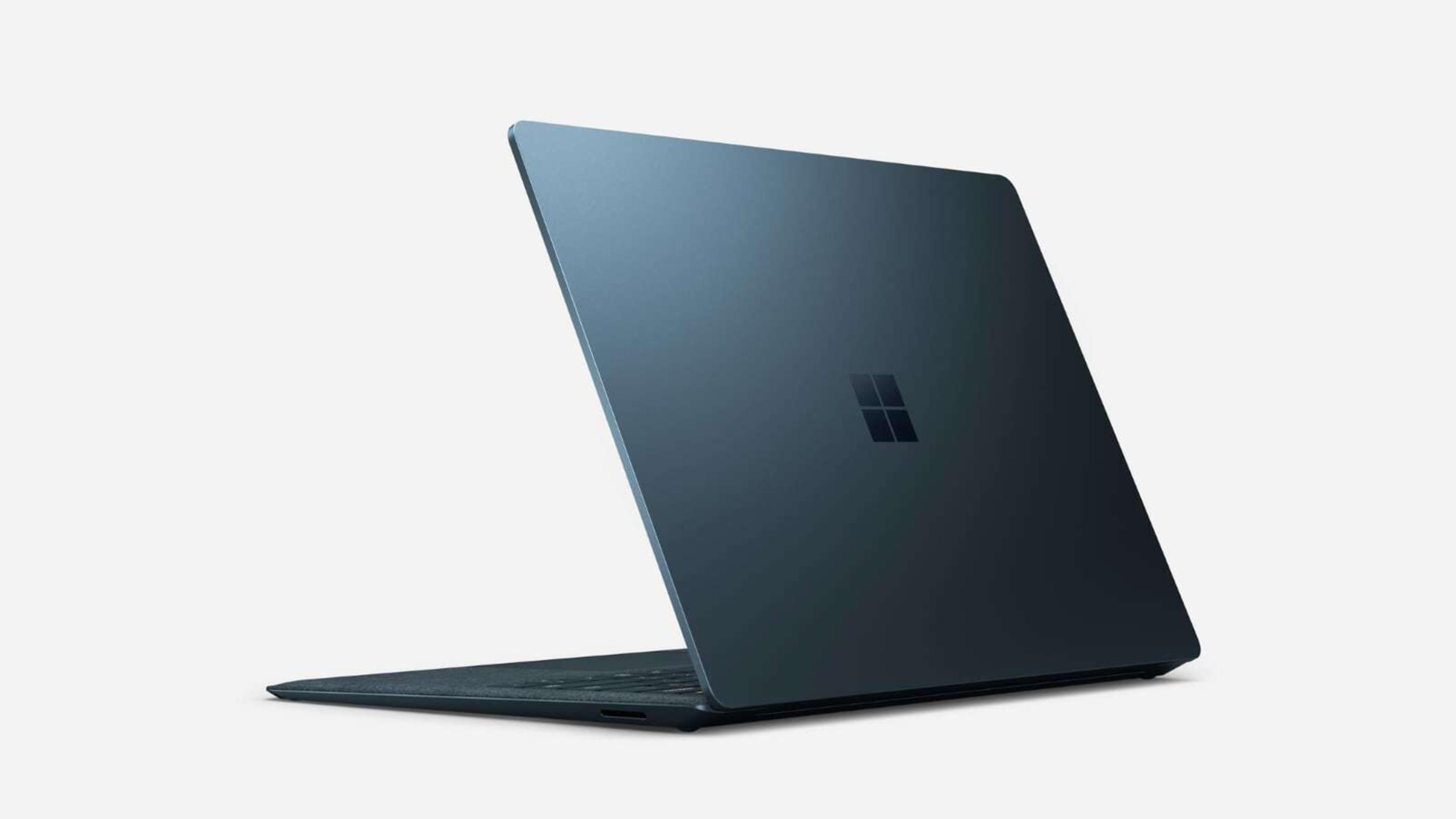 Blauer Microsoft Laptop von hinten, leicht geöffnet, mit Microsoft-Logo. Weißer Hintergrund, abgewinkelte Ansicht.