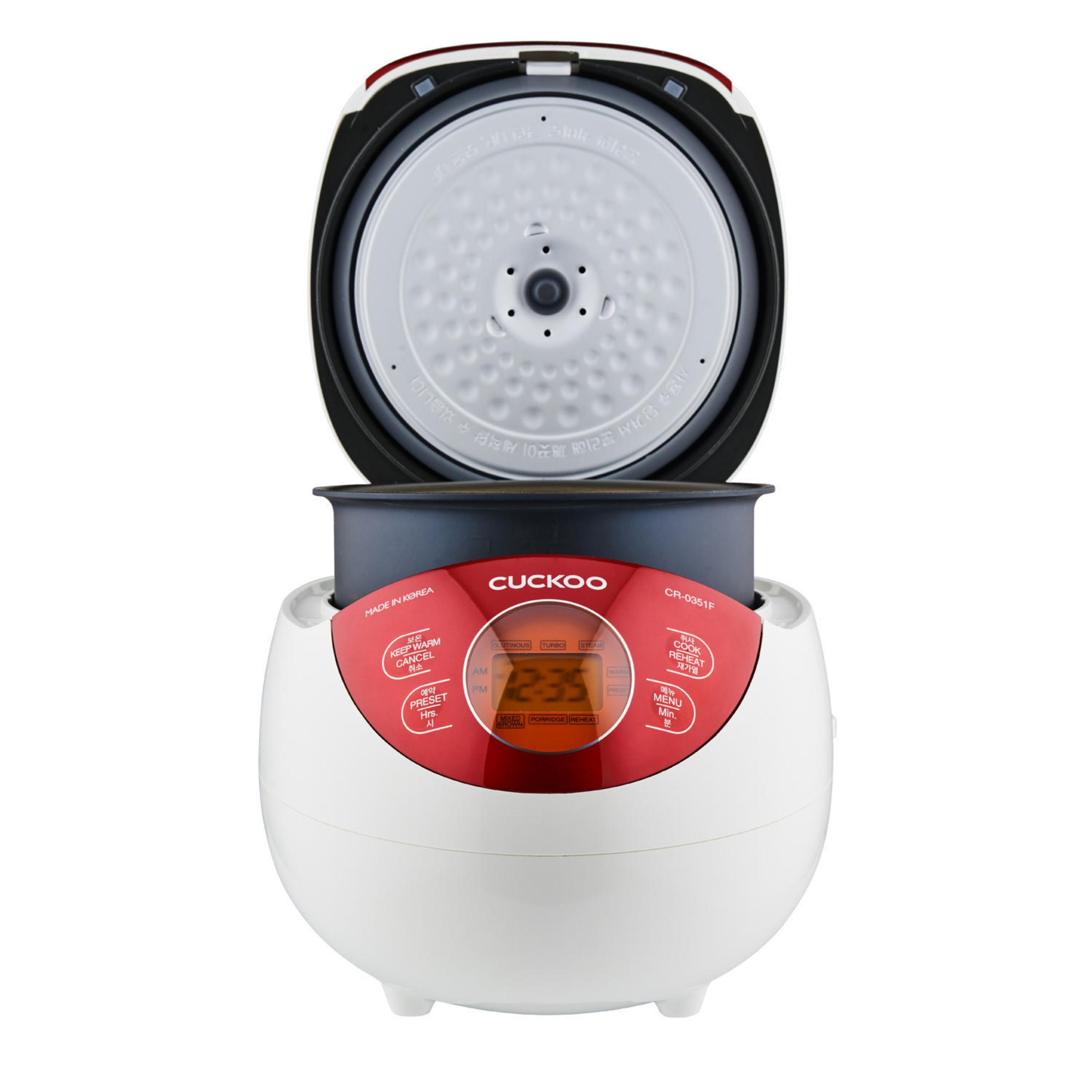 Biało-czerwony garnek do ryżu Cuckoo, otwarte wieczko, widoczny wyświetlacz cyfrowy.