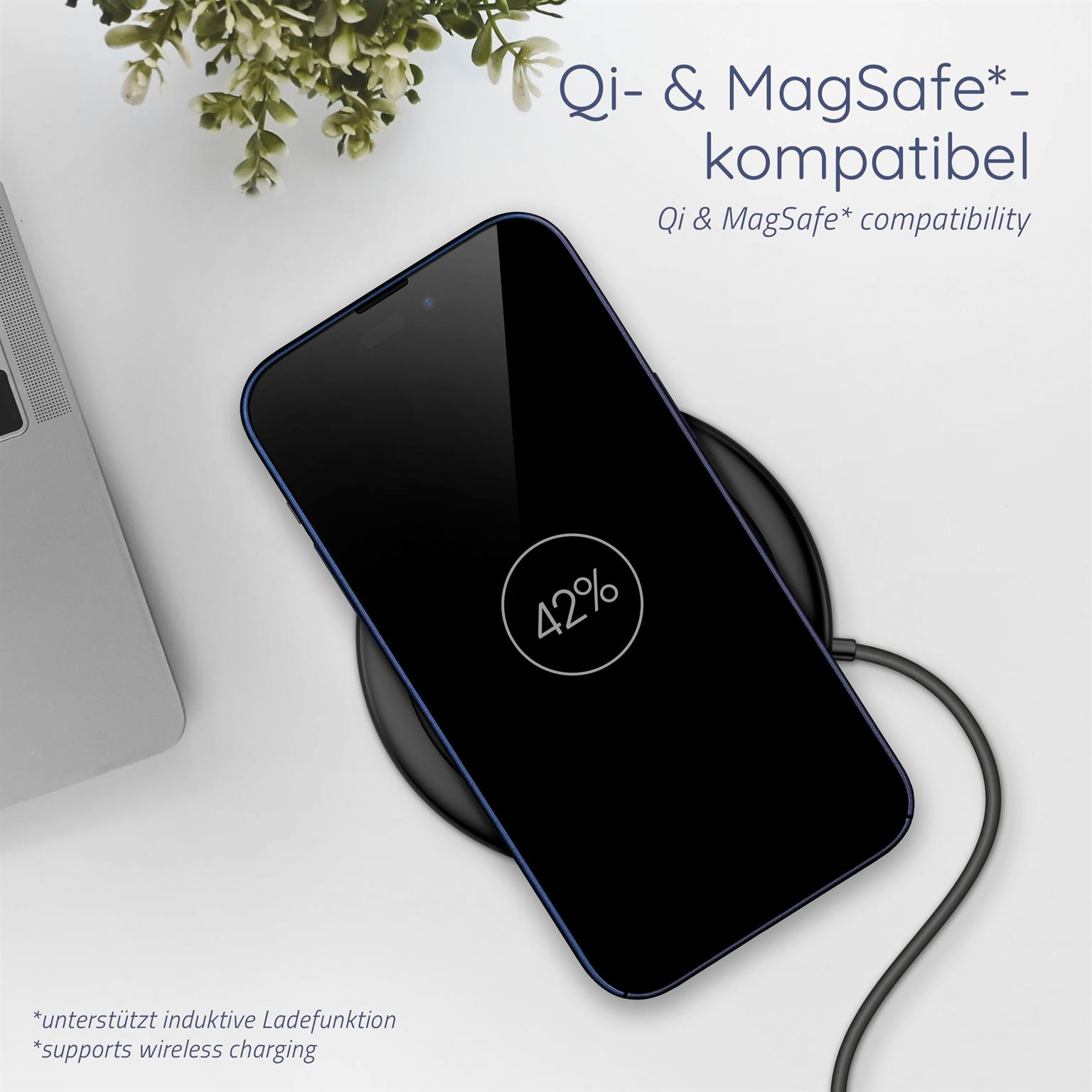 Telefon auf einem kabellosen Ladegerät, zeigt 42 % Ladung, mit einer Pflanze und einem Laptop im Hintergrund.