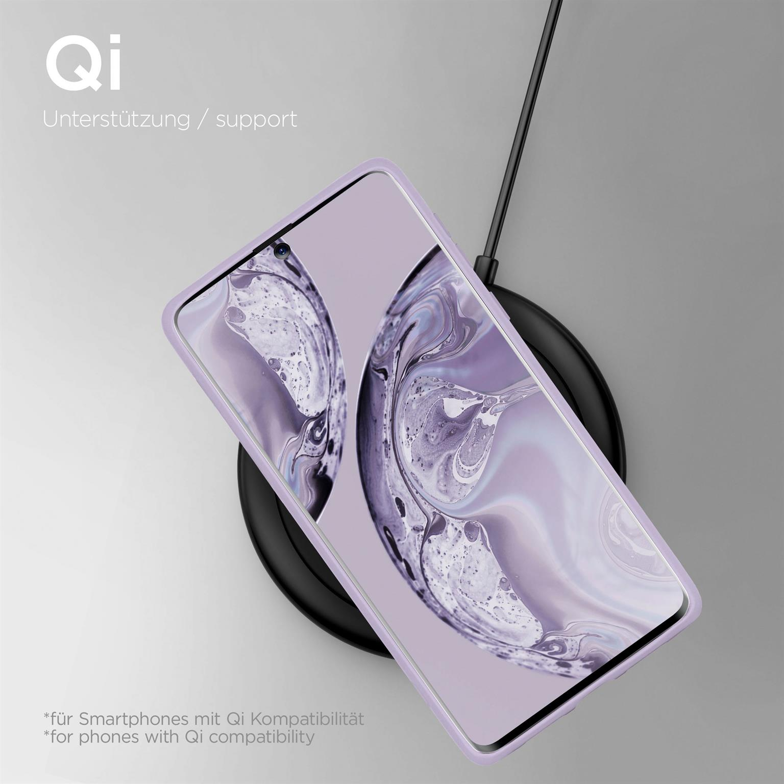 Telefon in lila Hülle auf kabellosem Ladegerät. Qi-Support-Etikett oben.