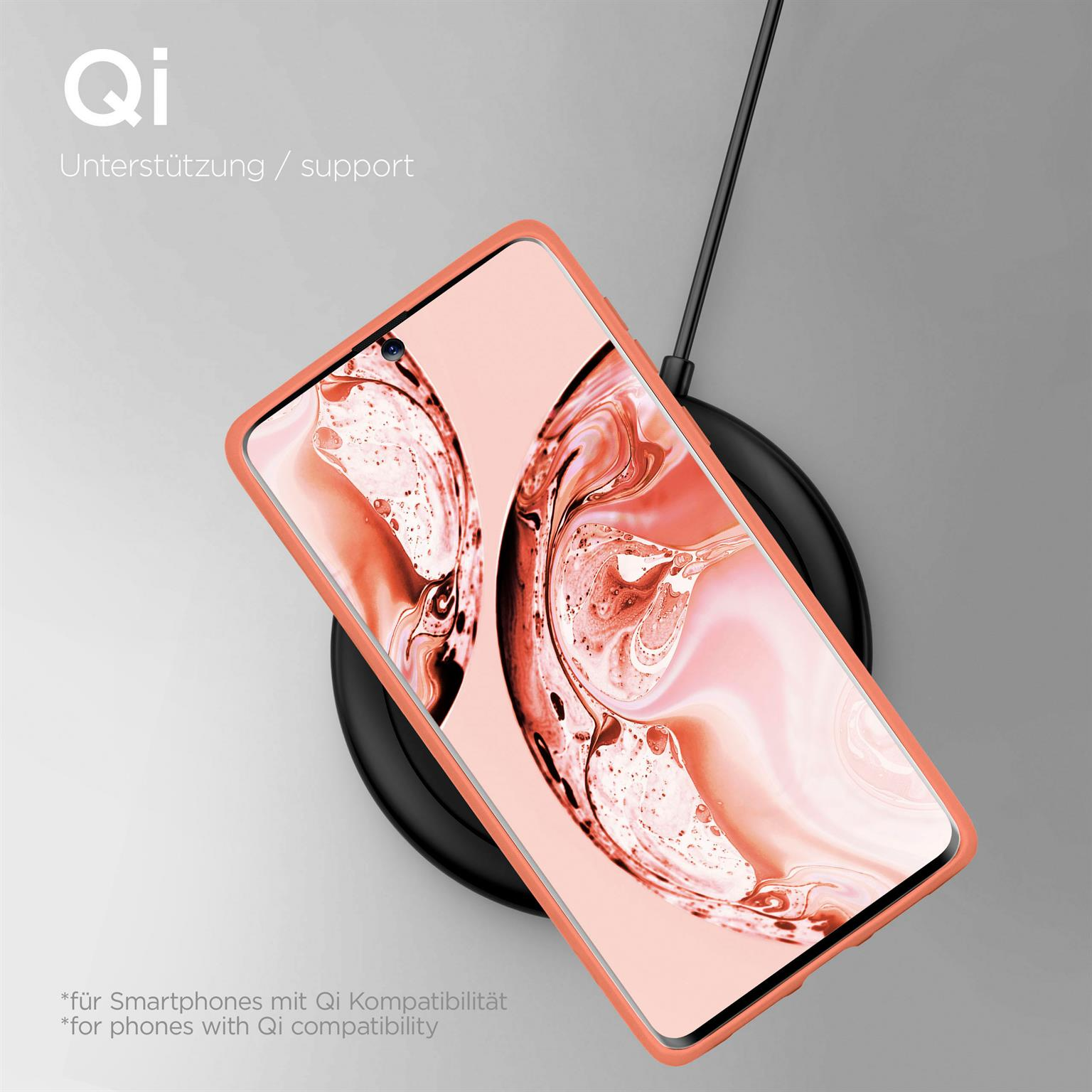 Telefon in einem pfirsichfarbenen Gehäuse auf einem kabellosen Ladegerät. Schwarzes Ladegerät, hellgrauer Hintergrund.