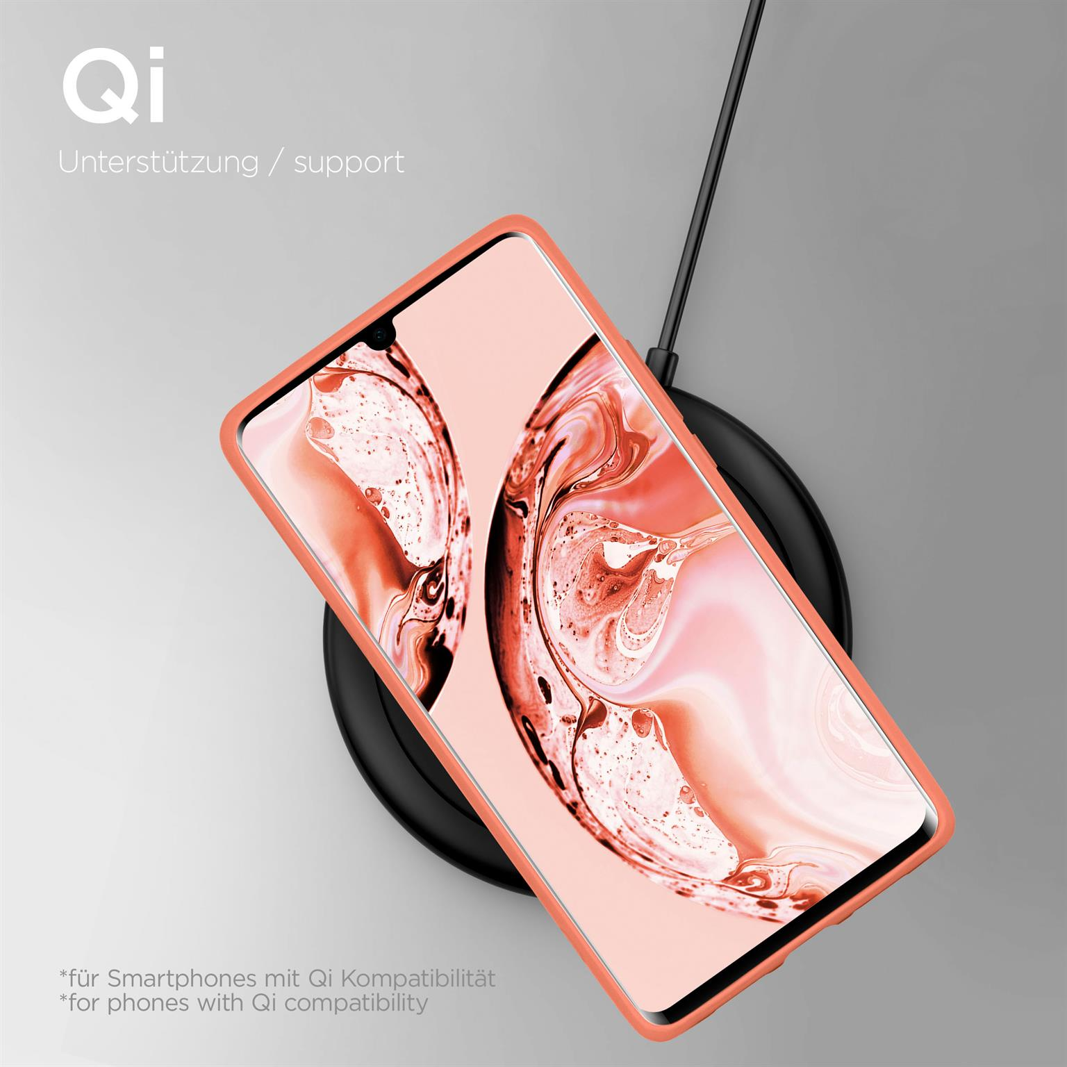 Telefon in pfirsichfarbener Hülle, drahtlos auf schwarzem Ladepad.