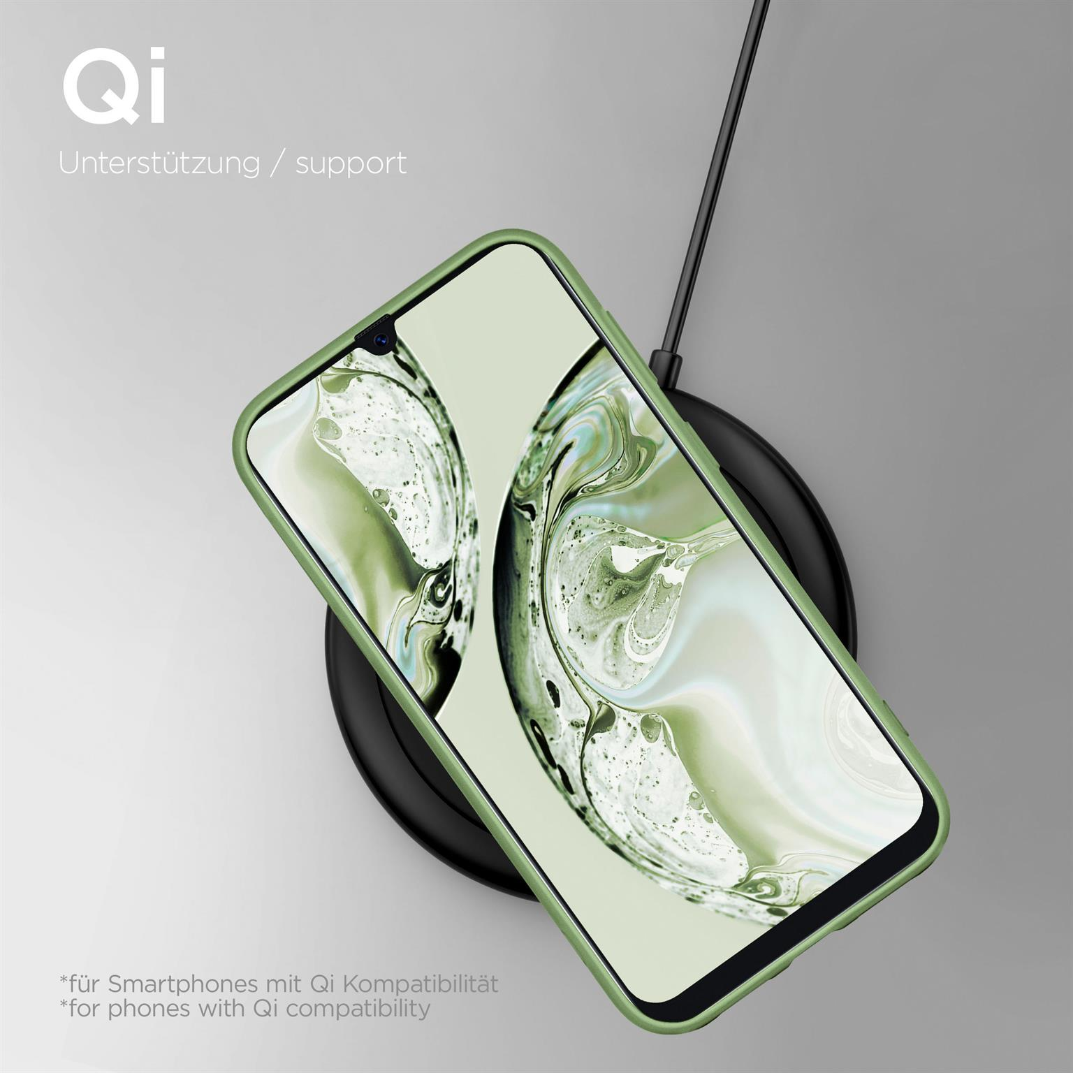 Telefon in grüner Hülle auf kabellosem Ladegerät. Schwarzes Pad, weißer Hintergrund.