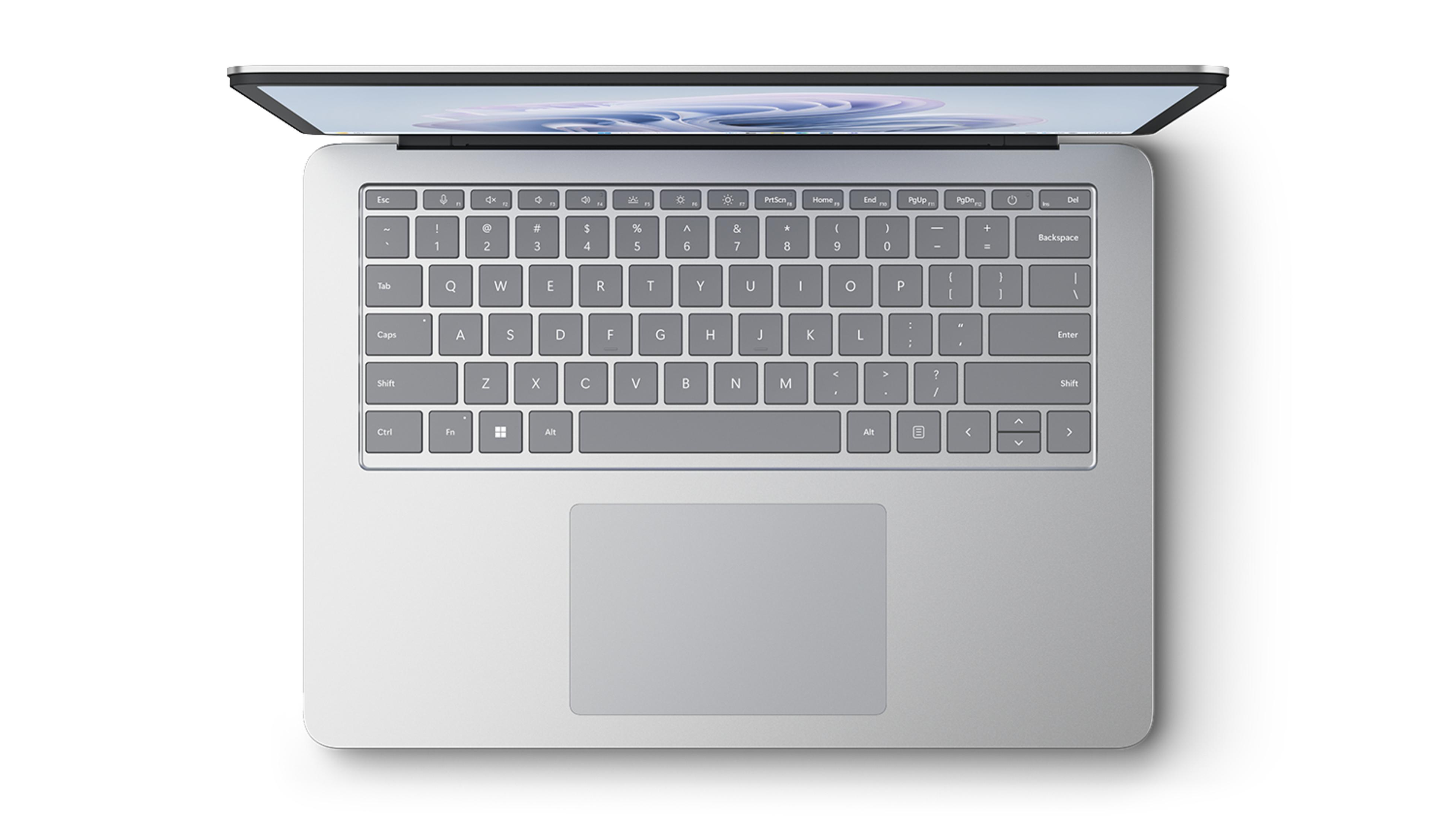 Draufsicht auf einen silbernen Laptop mit geöffnetem Display und Tastatur.