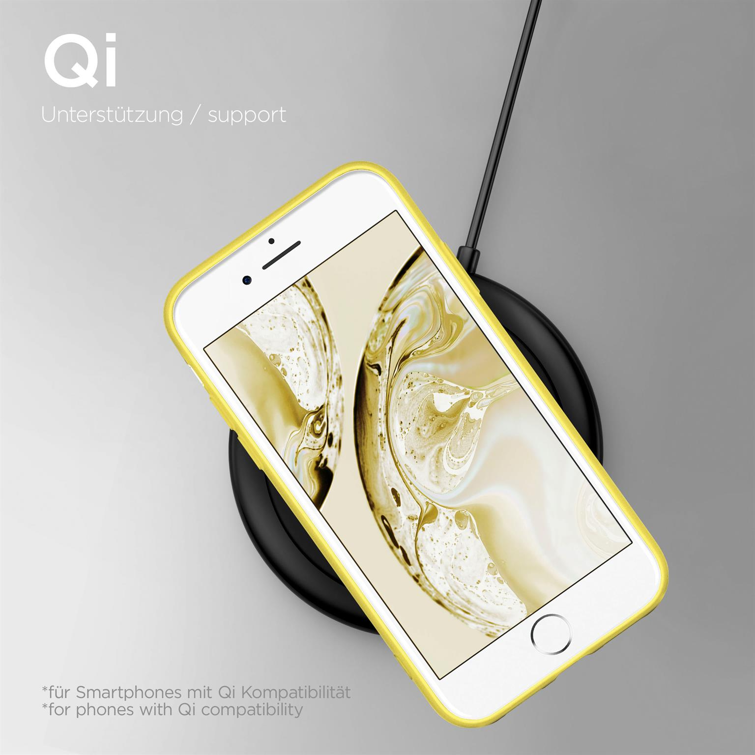 Weißes Telefon mit gelbem Gehäuse auf einem schwarzen kabellosen Ladegerät. Ein schwarzes Kabel verbindet das Ladegerät.