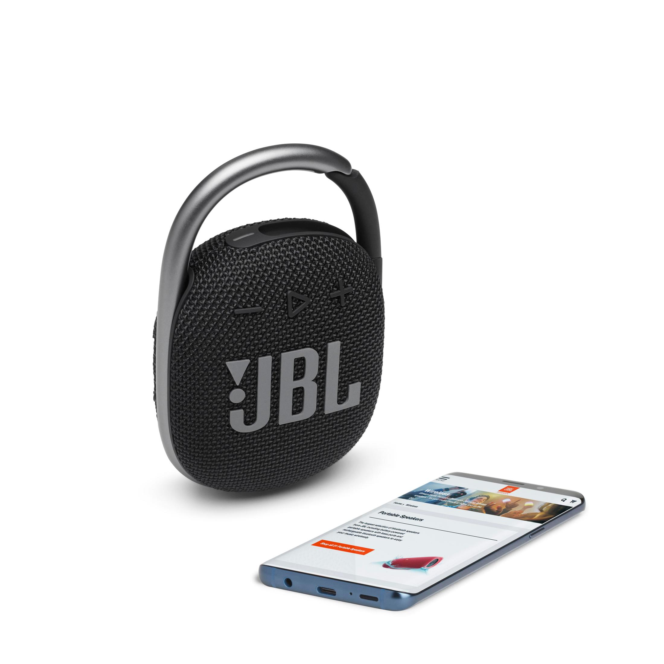 Głośnik JBL z uchwytem. Telefon ze stroną internetową JBL. Białe tło.