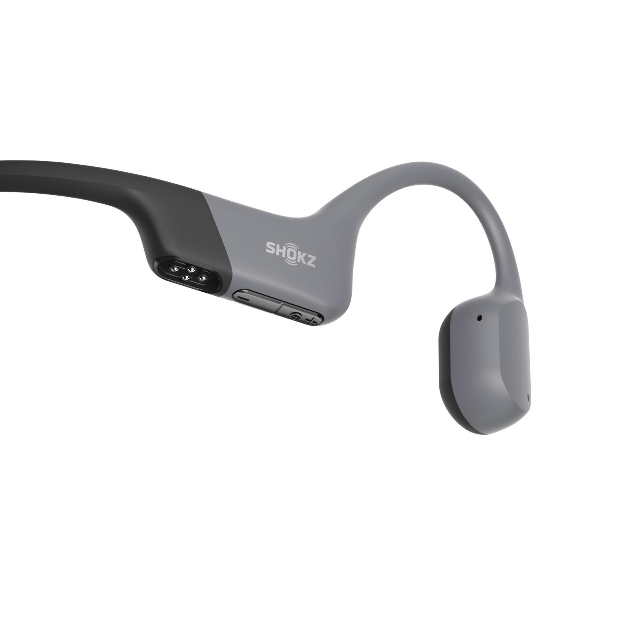 Cuffie a conduzione ossea SHOKZ grigie. Il design avvolge la testa, con auricolari vicino alle orecchie.