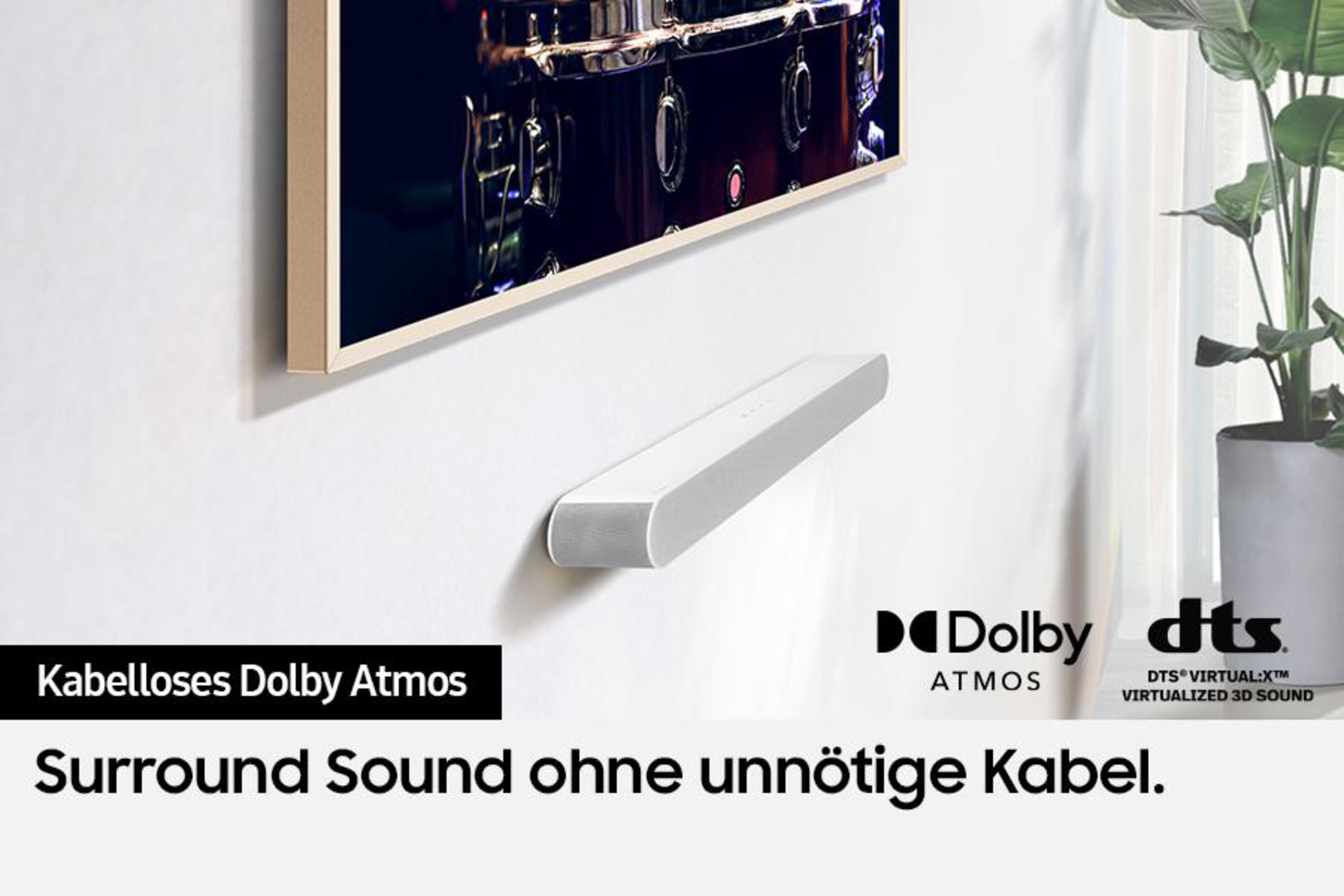 Weiße Soundbar unter einem Fernseher an einer weißen Wand. Text: Dolby Atmos.