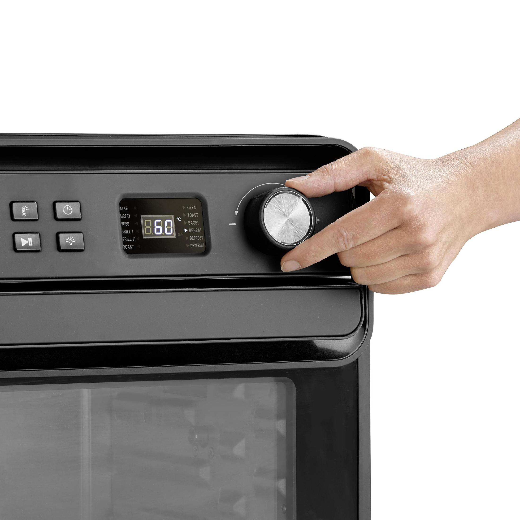 Una mano ruota una manopola su una friggitrice ad aria nera, con un display delle impostazioni.