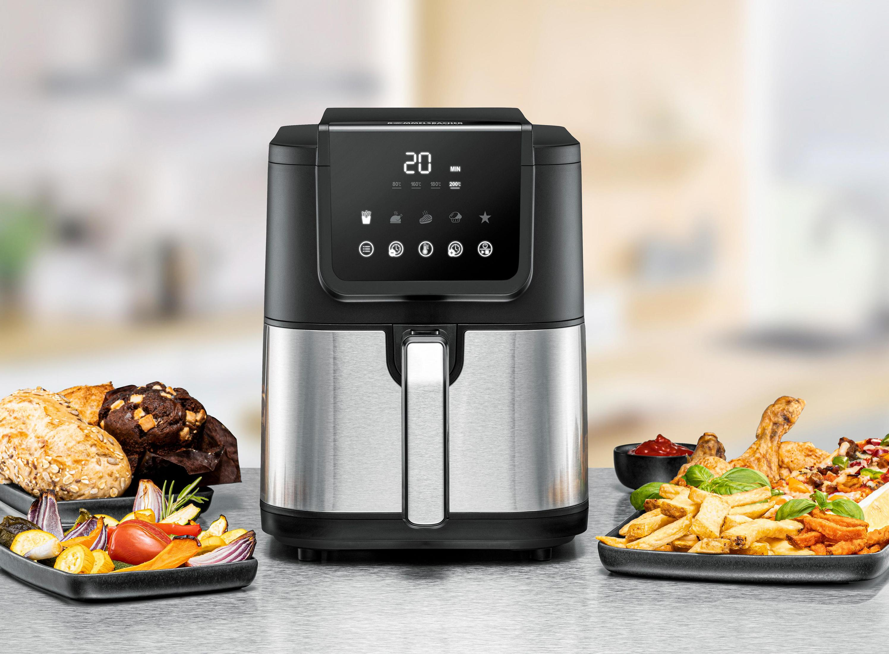 Frytownica powietrzna z jedzeniem. Dania obejmują frytki, smażonego kurczaka i pieczone warzywa.