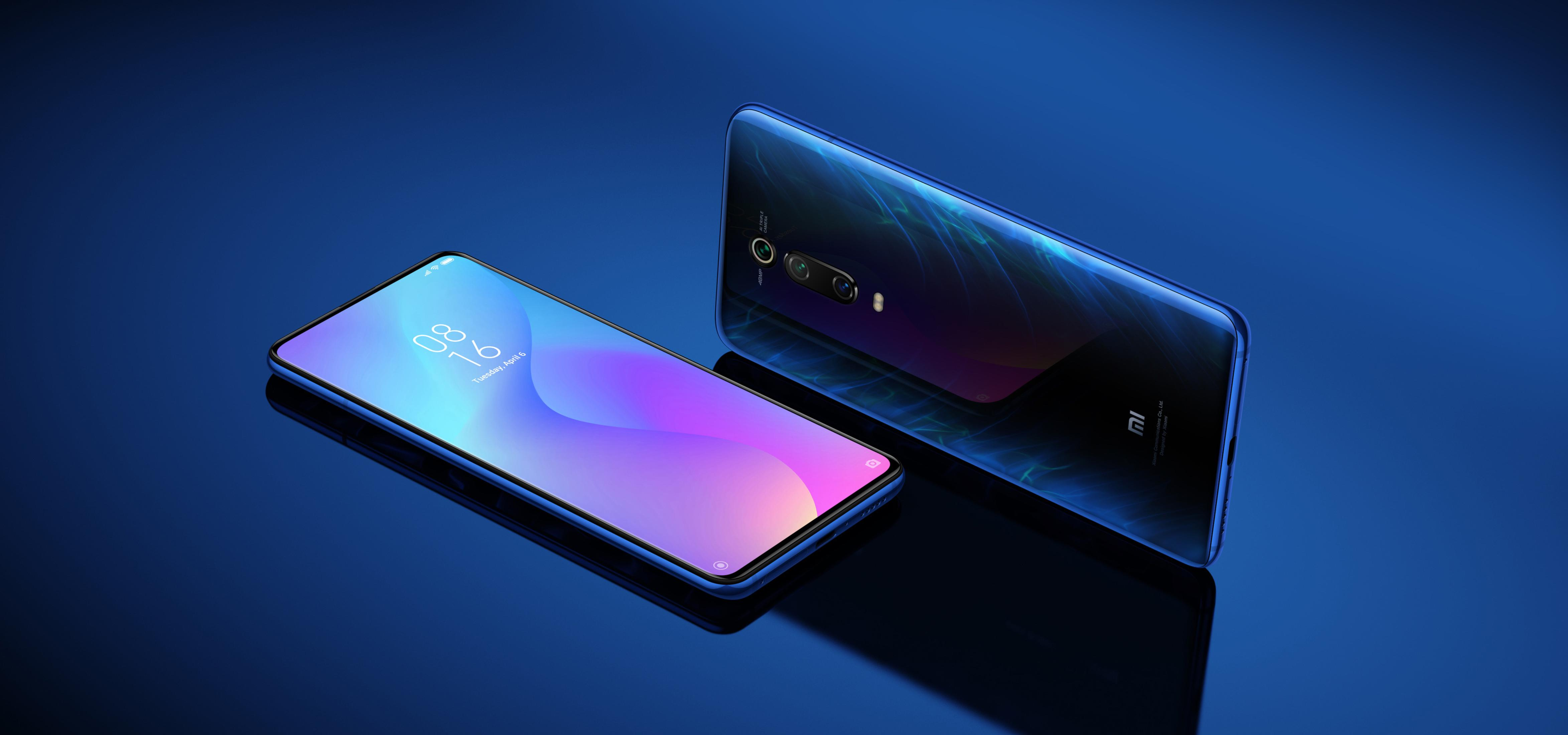 Zwei blaue Telefone spiegeln sich auf einer blauen Oberfläche gegenseitig.