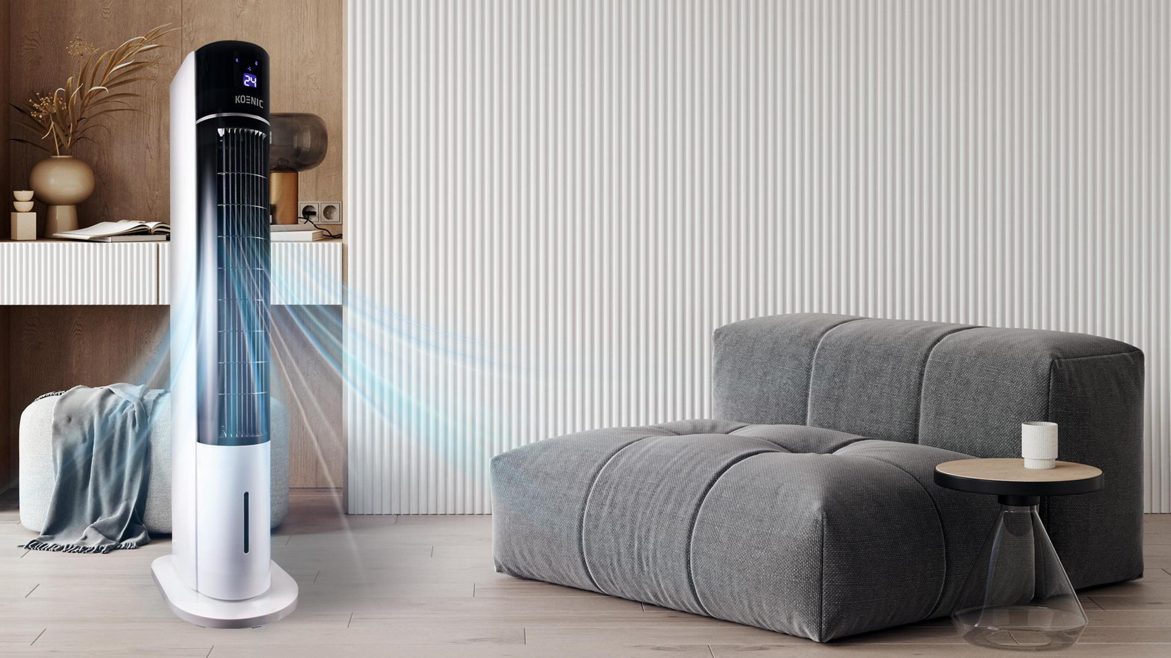 Weißer und schwarzer Luftkühler neben einem grauen Sofa in einem Raum.