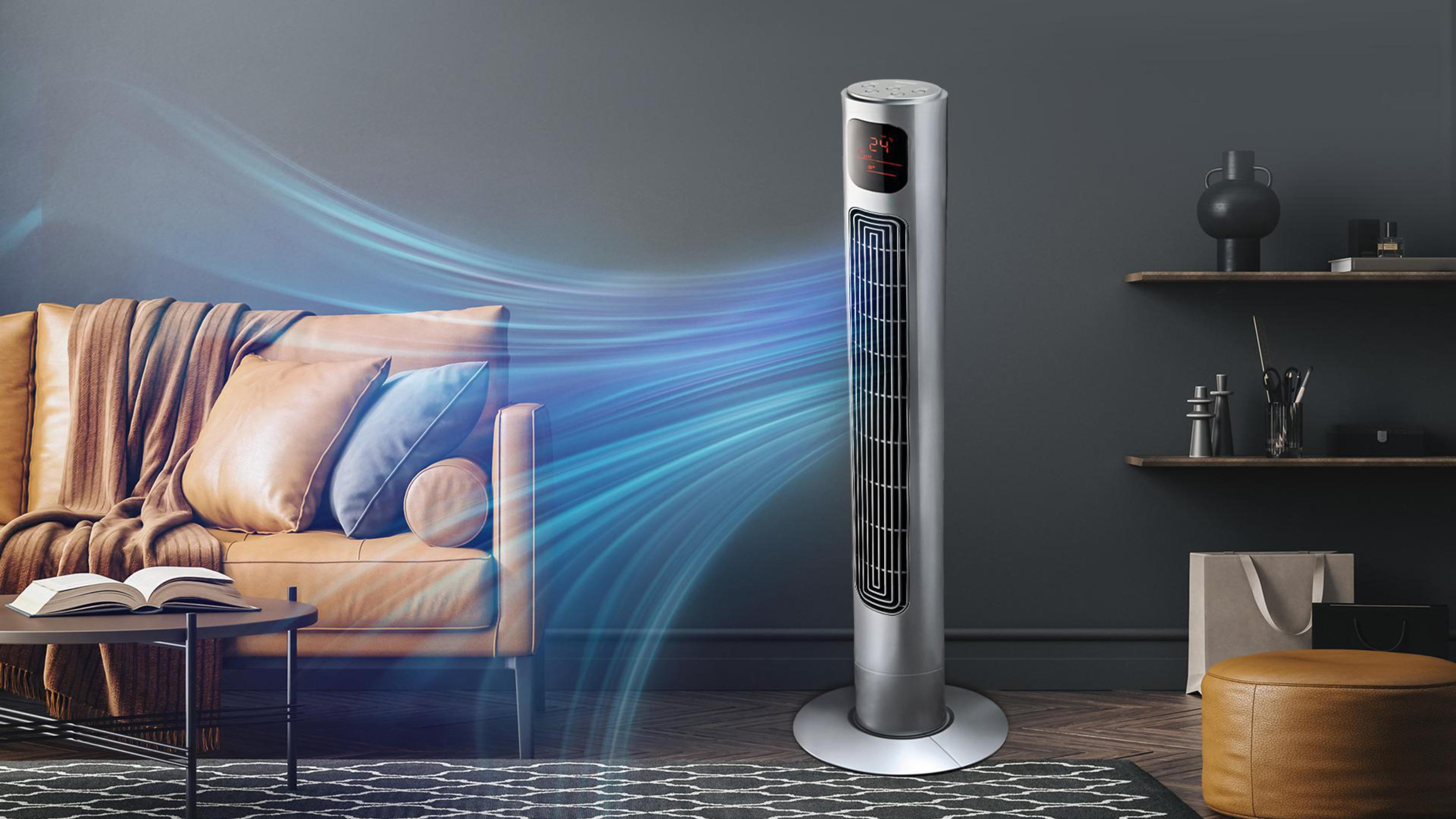 Ein silberner, modern aussehender Ventilator in einem Wohnzimmer, mit Luftstrom zur Couch.