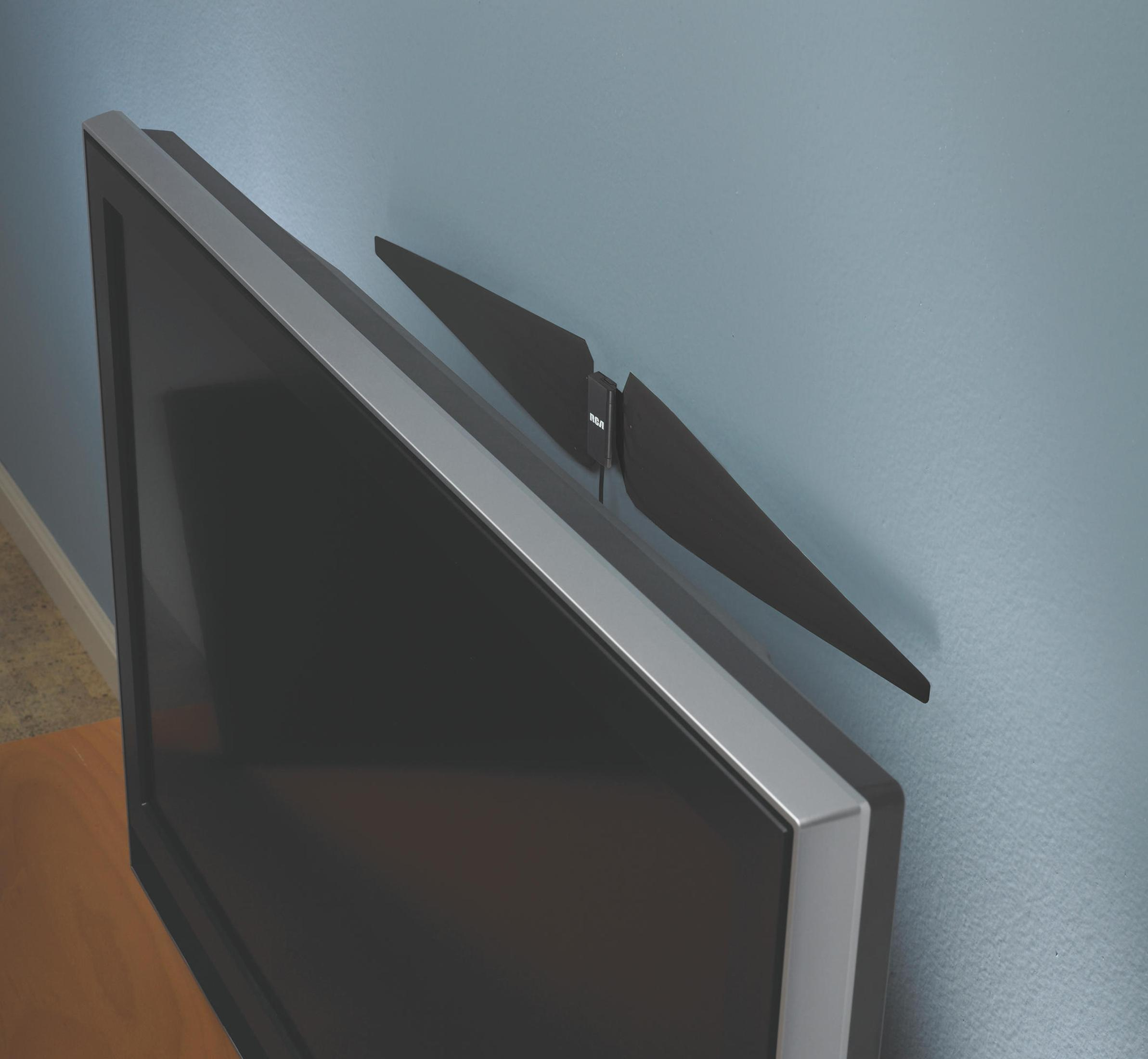 TV-Antenne am Fernseher befestigt. Die Antenne ist schwarz und die Wand hellblau.