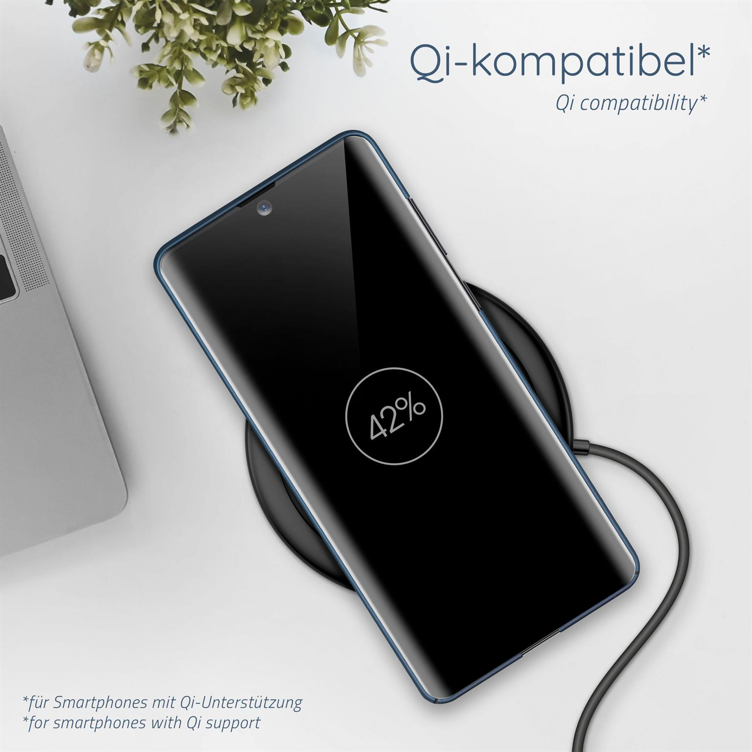 Ein Telefon, das kabellos geladen wird und 42 % anzeigt. Ein schwarzes Ladepad liegt auf weißer Oberfläche.