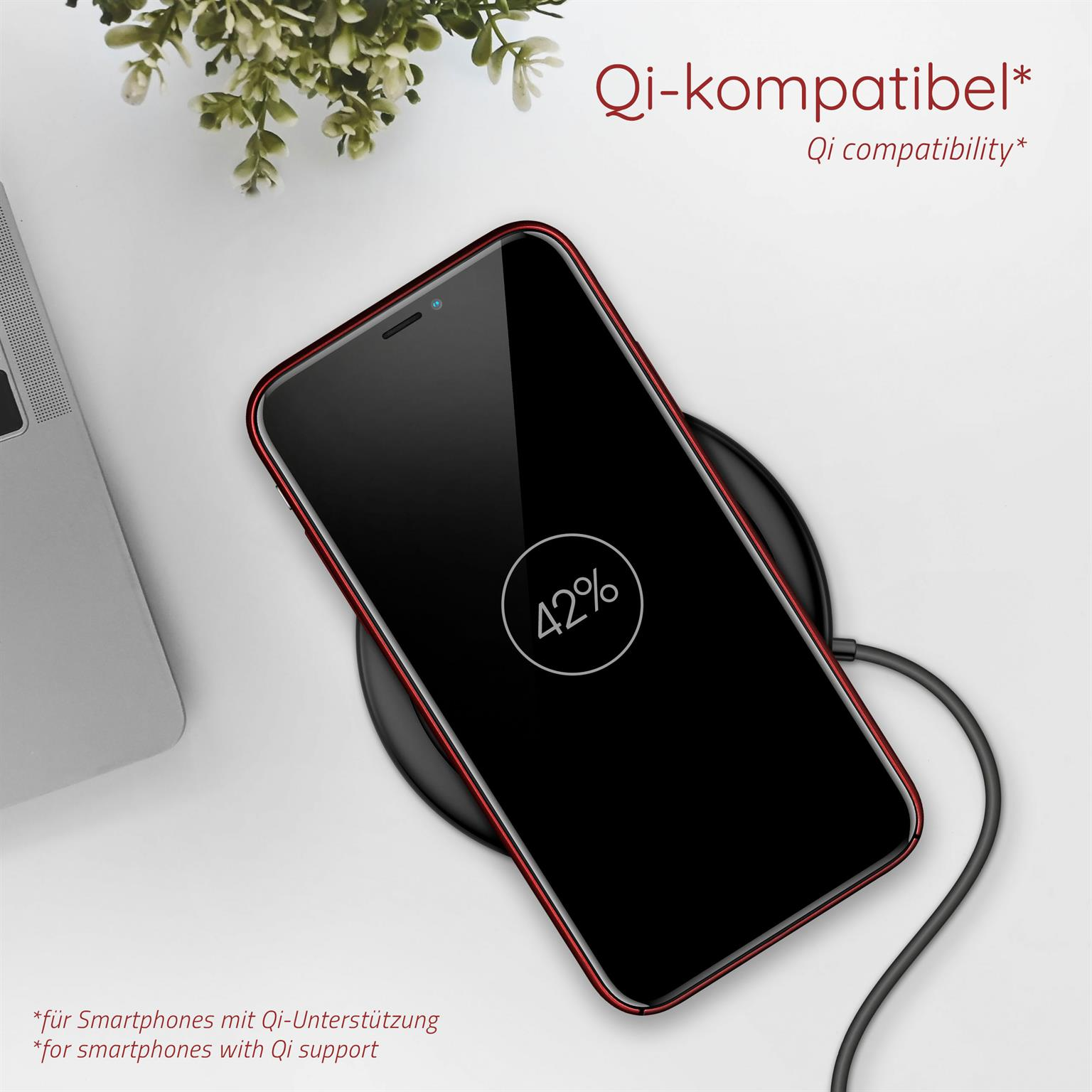 Telefon lädt auf kabellosem Ladegerät. Telefon hat rotes Gehäuse und zeigt 42% Akku auf schwarzem Bildschirm.