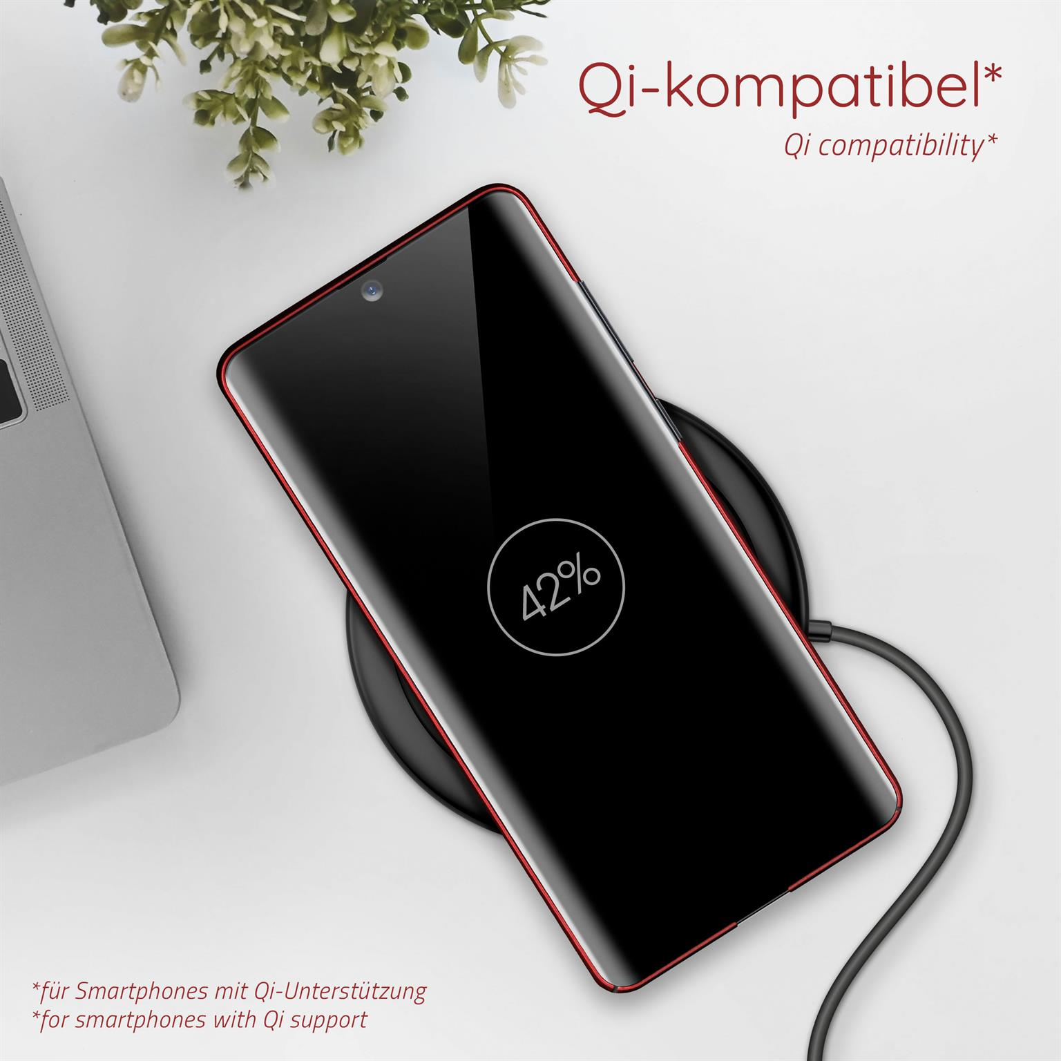 Ein Telefon wird drahtlos aufgeladen. Das Telefon ist schwarz mit rotem Rand.