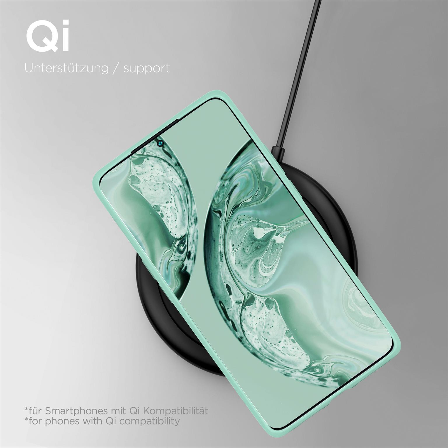 Grüne Handyhülle auf Ladepad, mit Telefon, das abstraktes Kunstdesign zeigt.