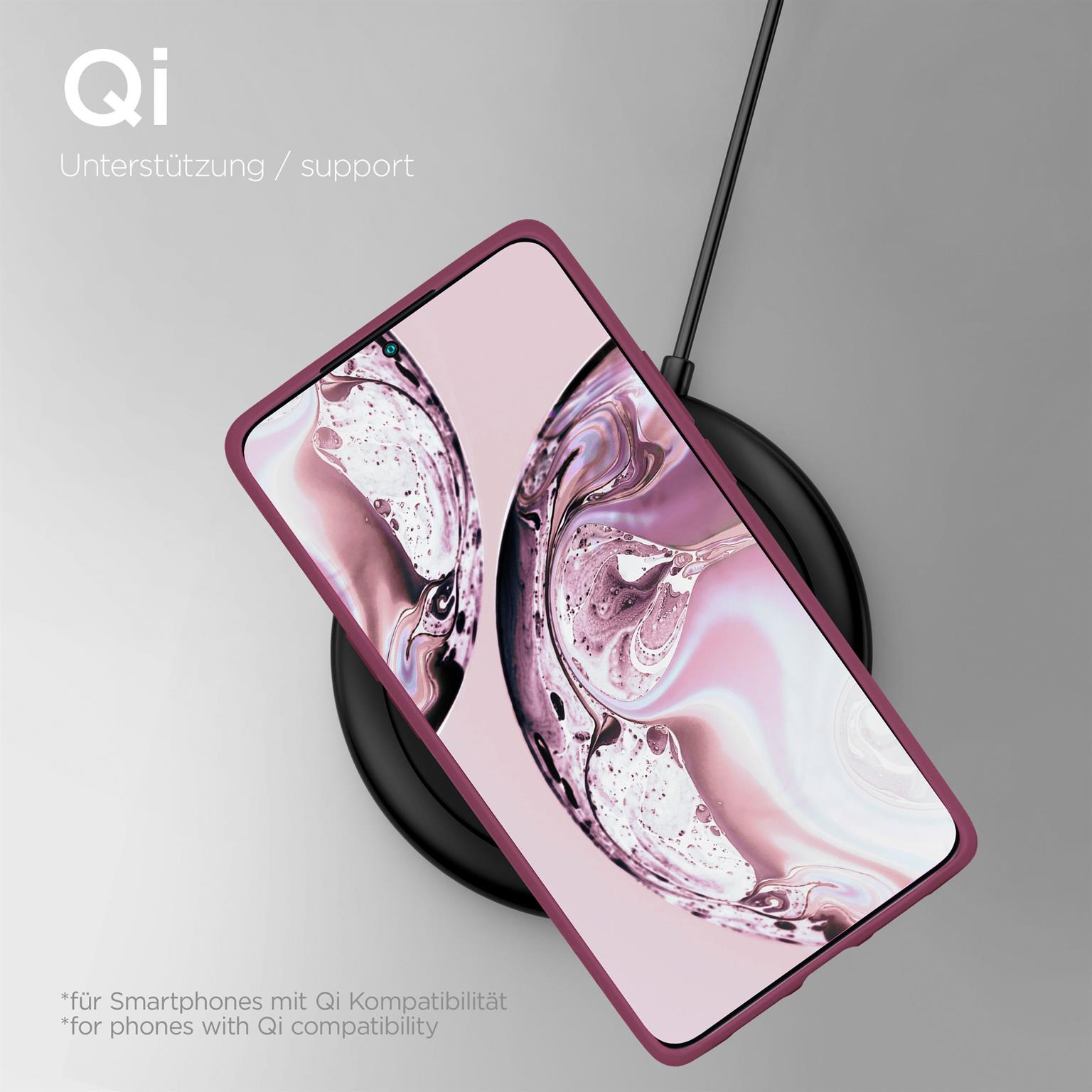 Ein Telefon in einer lila Hülle wird auf einem schwarzen kabellosen Ladegerät aufgeladen. Text: Qi-Unterstützung.