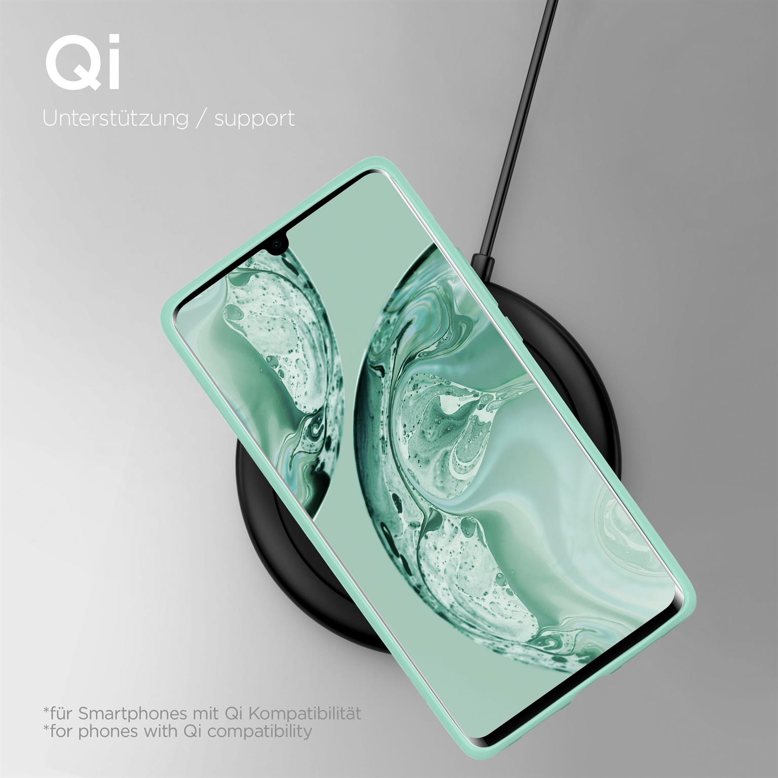 Ein Telefon mit mintgrüner Hülle, das auf einem kabellosen Ladepad geladen wird. Draufsicht.