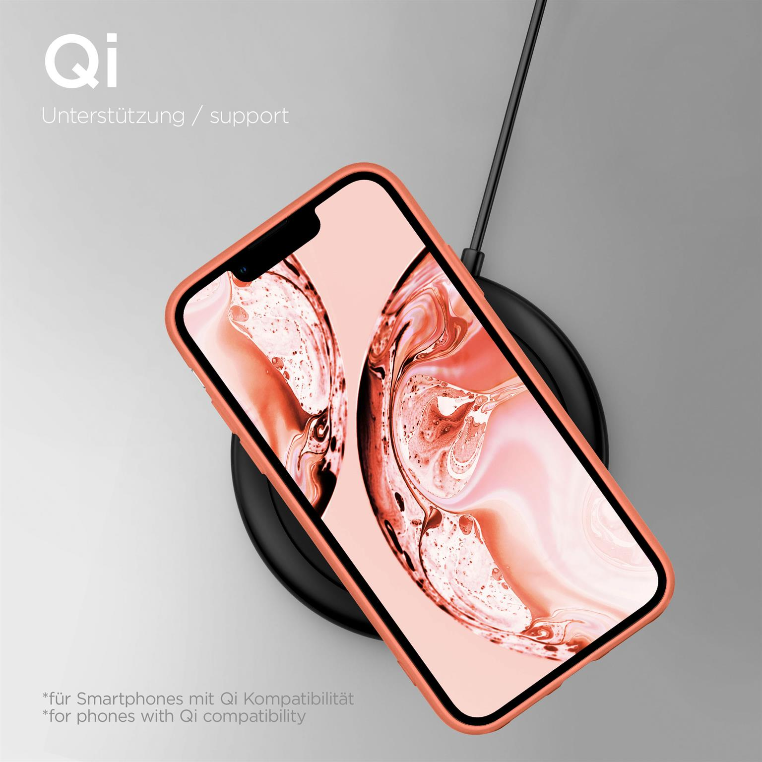 Pfirsichfarbenes Telefon in einer Hülle, das auf einem schwarzen kabellosen Ladegerät liegt.