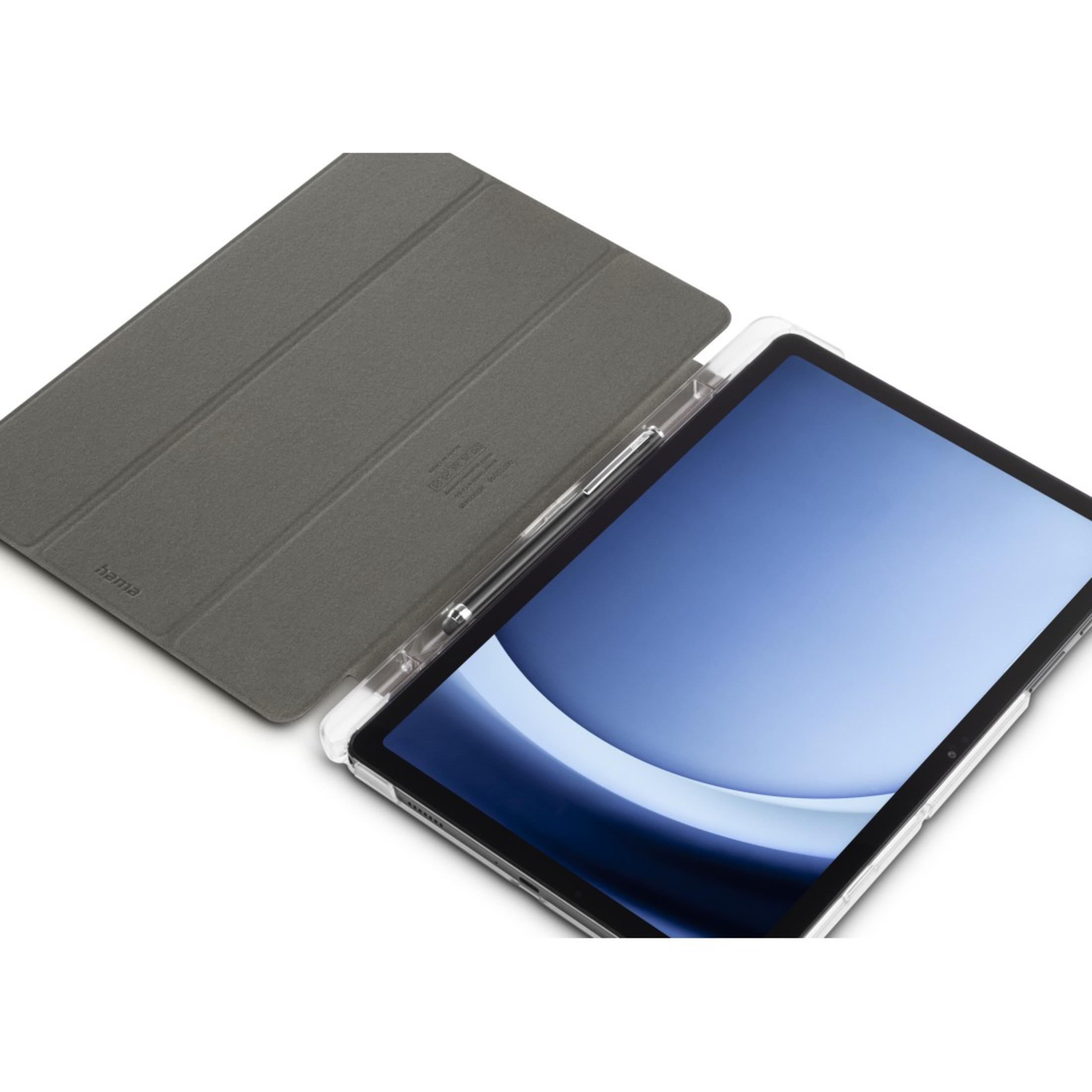 Tablet z etui. Ekran tabletu jest niebieski. Pióro leży na etui. Białe tło.