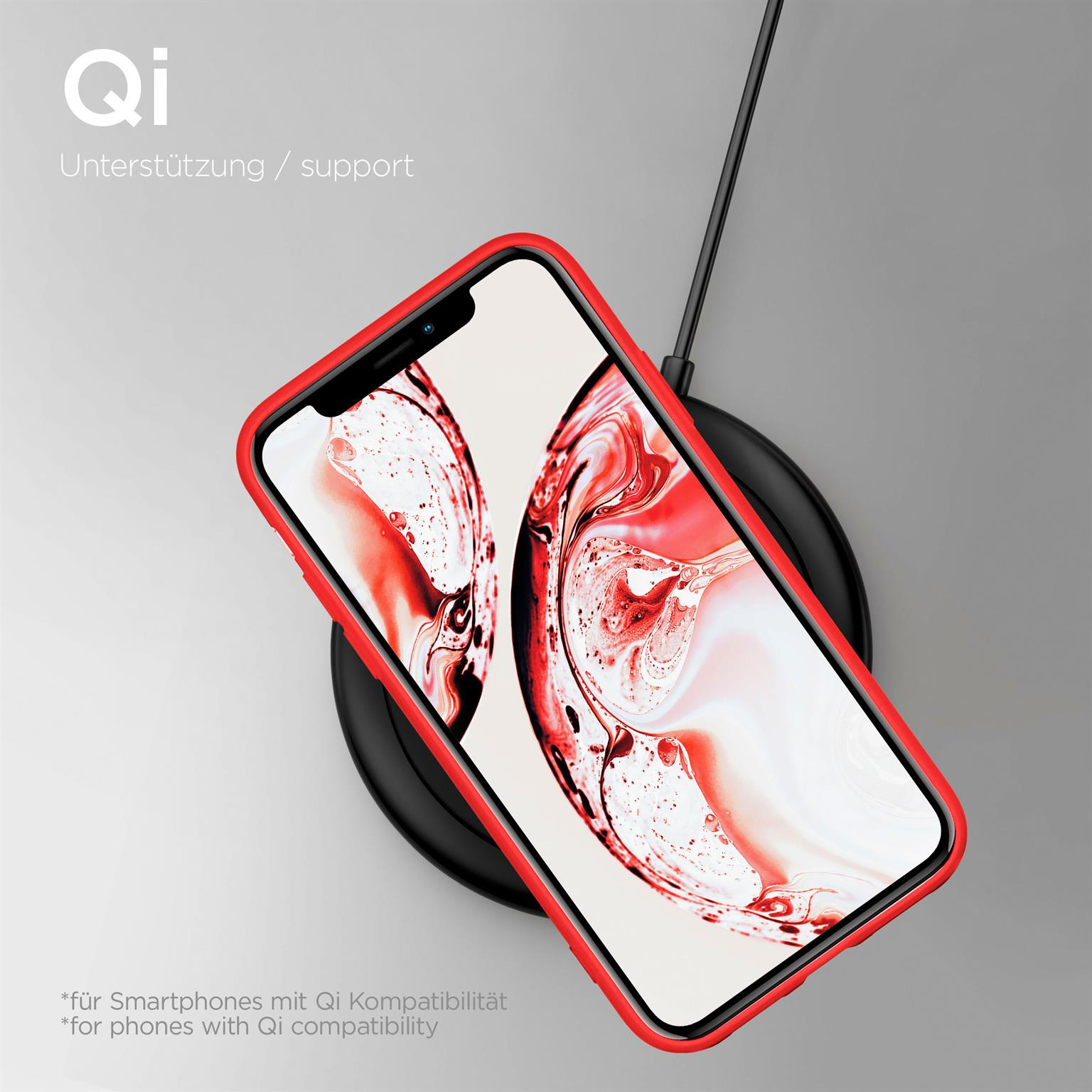 Ein rotes Telefon mit Hülle, das kabellos geladen wird. Ein schwarzes Ladegerät steht auf grauer Oberfläche.