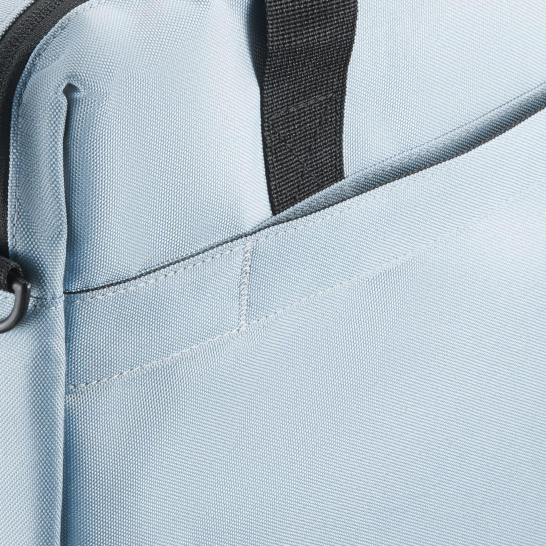 Primo piano di una borsa azzurra con cinturino nero. Il tessuto ha una trama sottile.