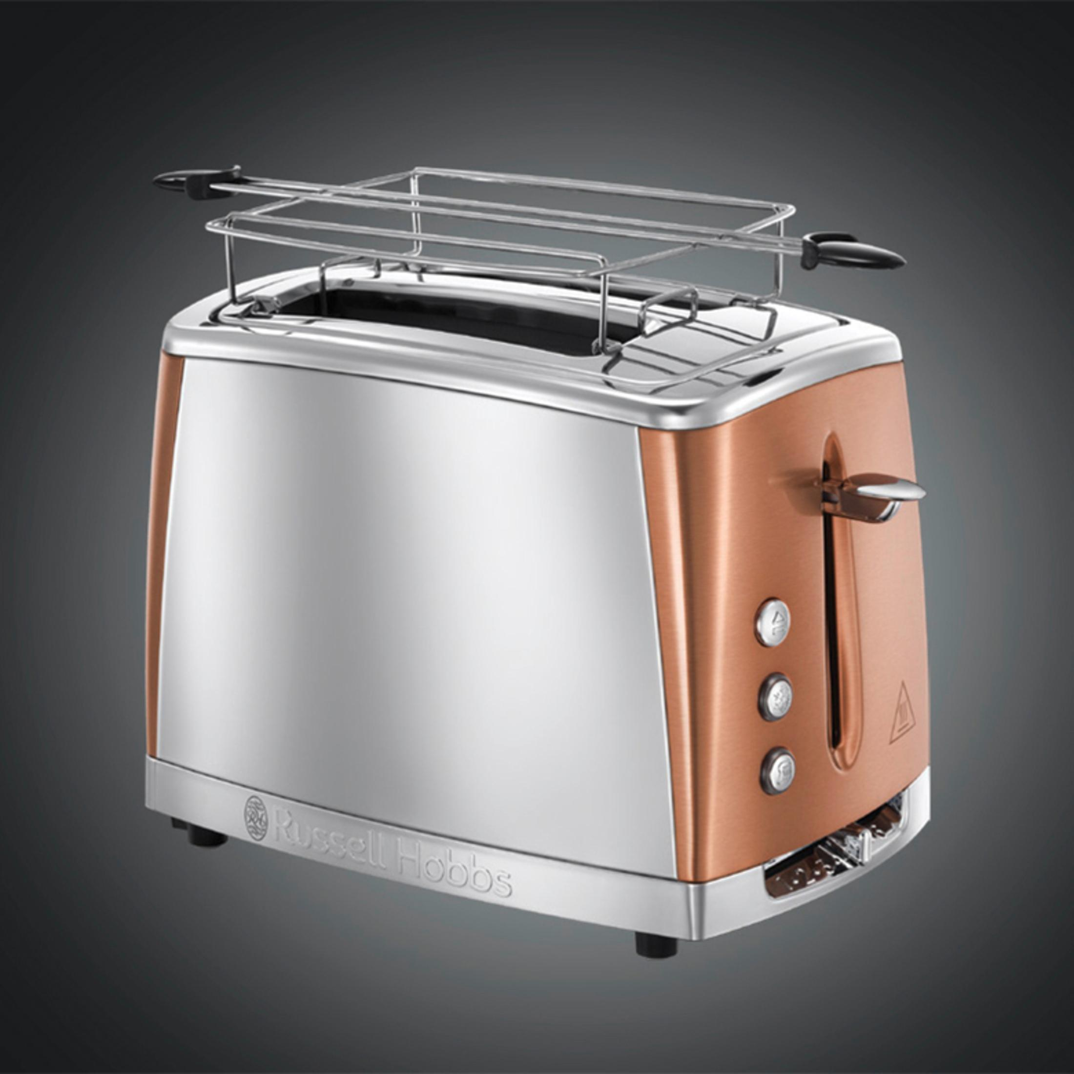 Ein Kupfer- und Silbertoaster mit Gestell auf dunklem Hintergrund.