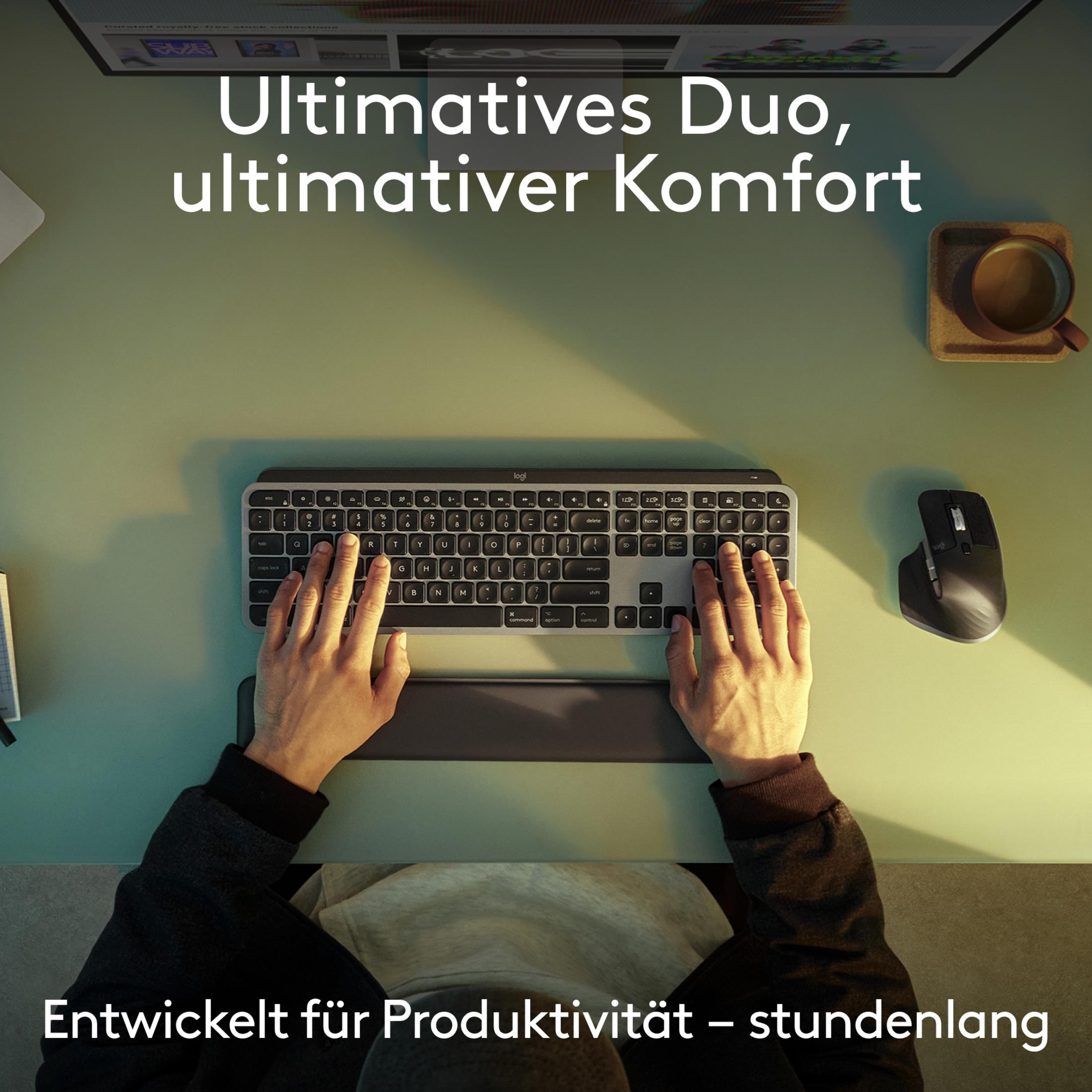 Draufsicht auf Hände einer Person auf Tastatur und Maus auf einem Schreibtisch.